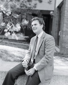 black and white photo of a man sitting outside