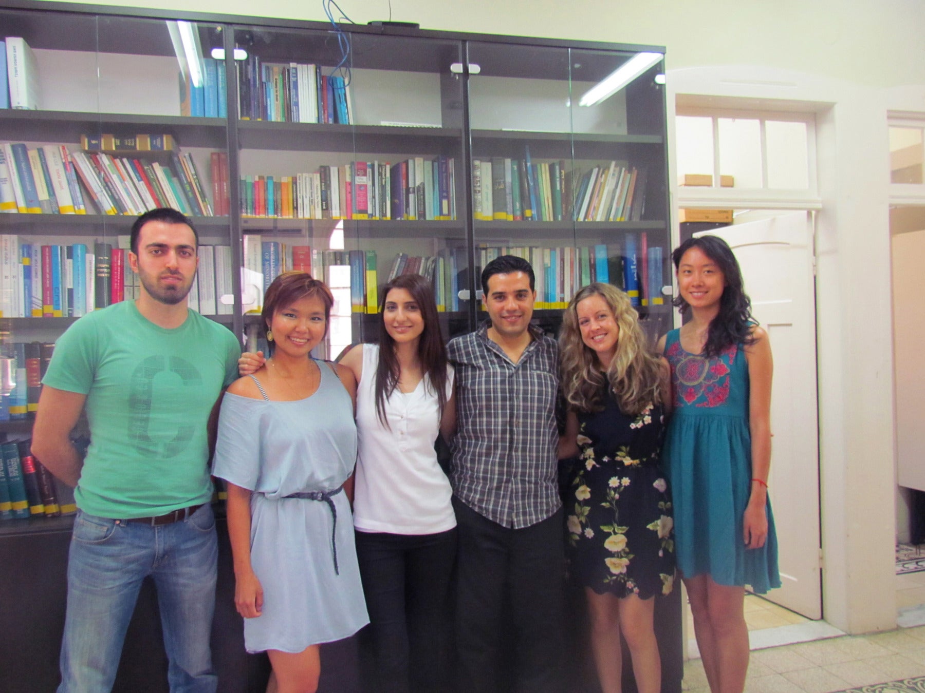 A group of people posing together in front of a bookshelf