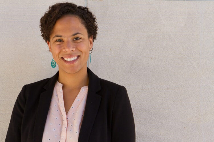 Tori Anderson in a black blazer and green earrings.