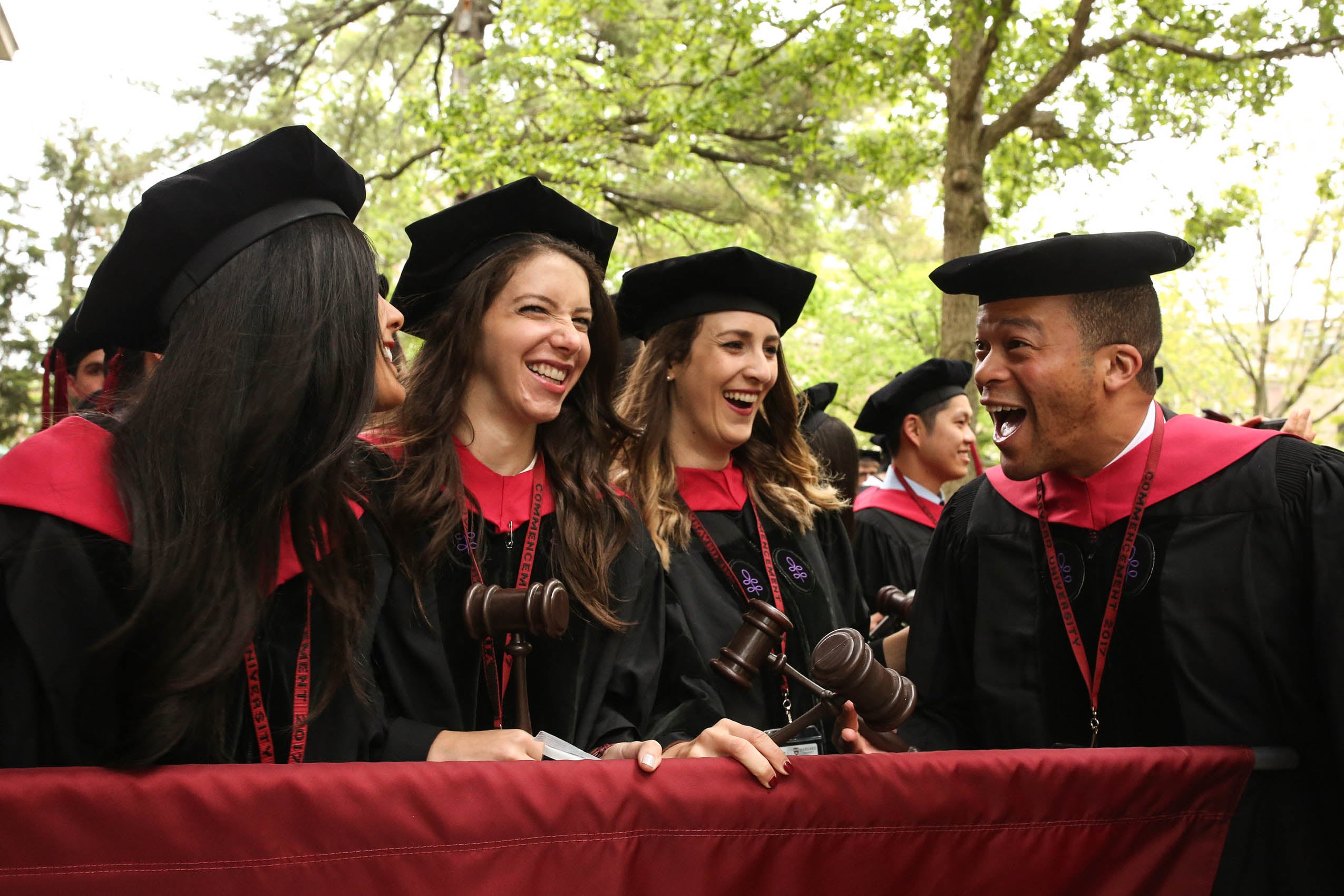 Four students holding gavels smiling at each other