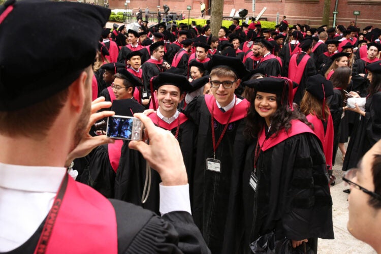 Three students pose for a photo, taken by another student