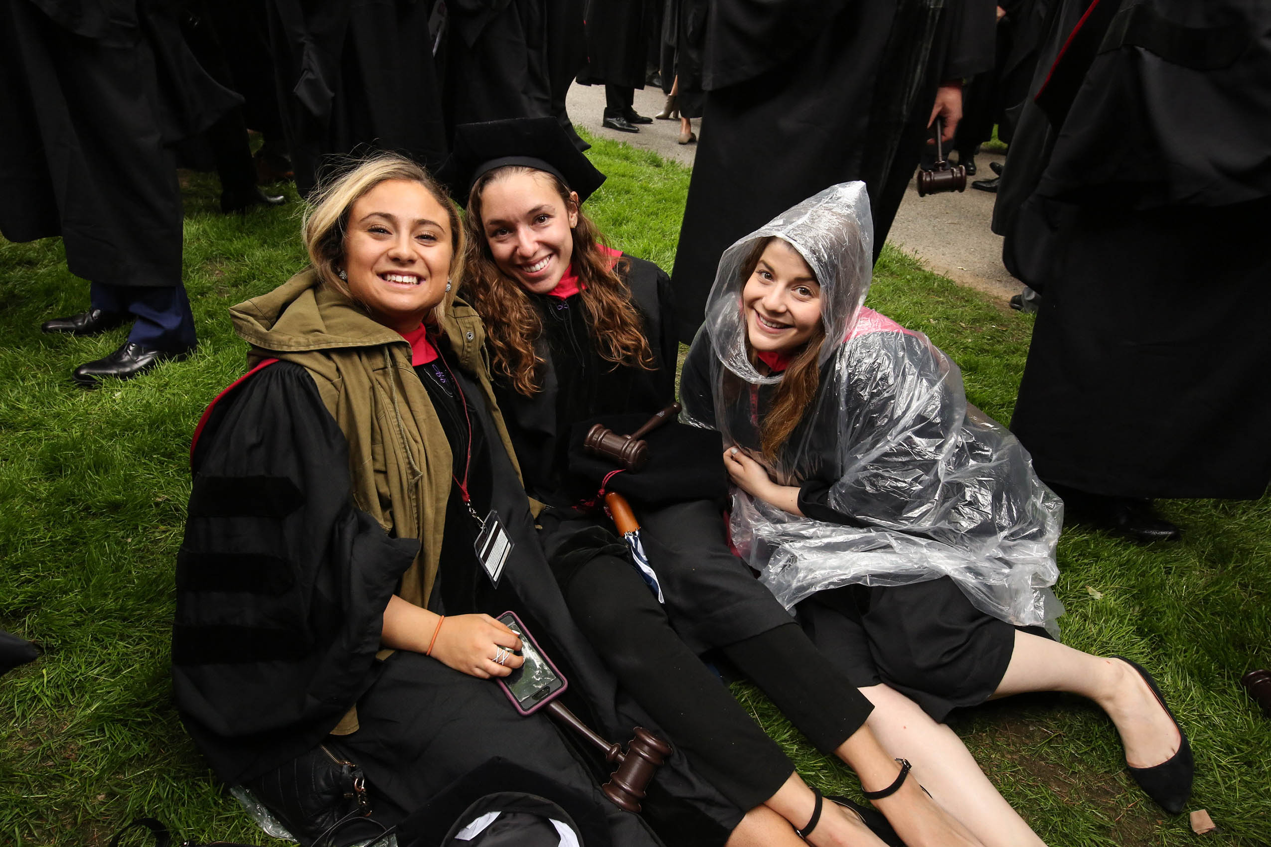 Three women sitting on Holmes Field, smiling