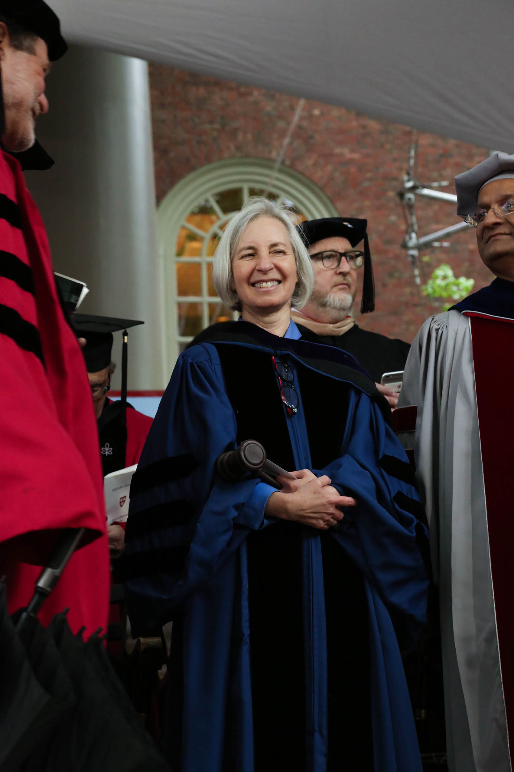 A woman in cap and gown, holding a gavel