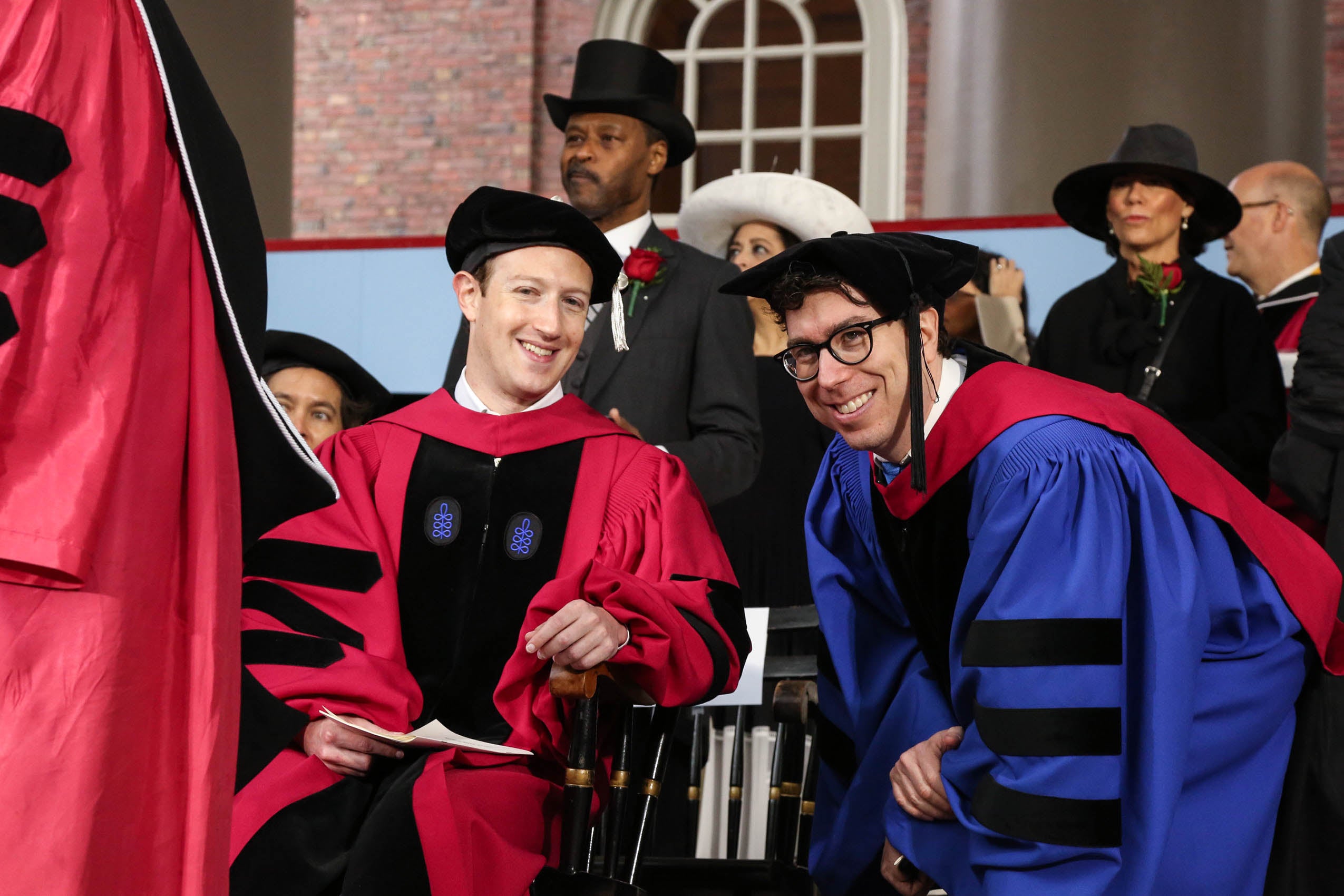 Two men in cap and gown, smiling
