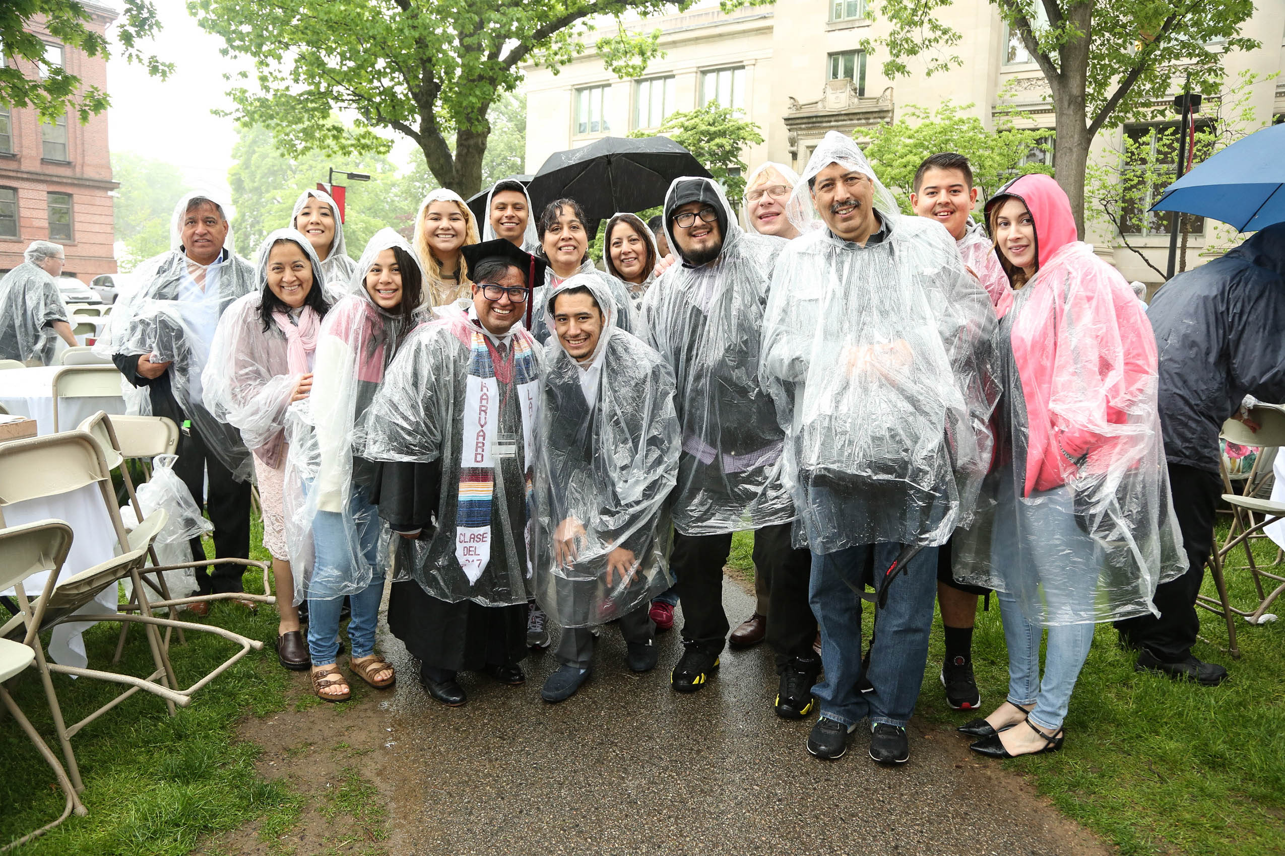 A group of people in plastic ponchos on Holmes Field, smiling
