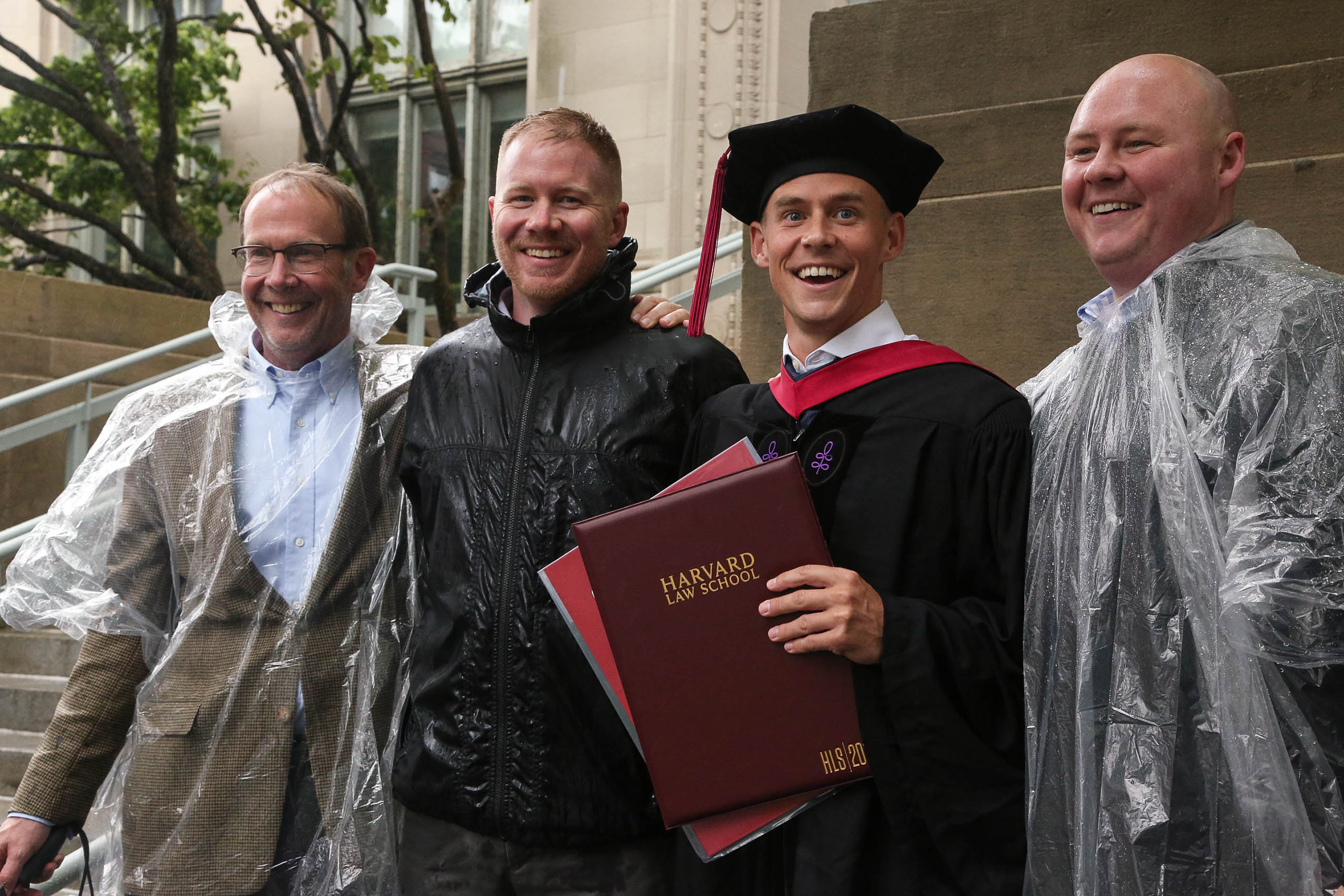 Four men standing together, smiling