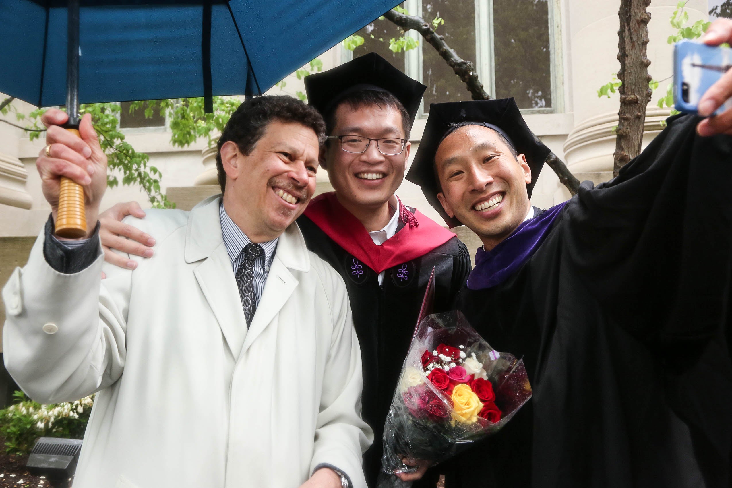 Three men standing together, smiling