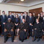 Dean John Manning (standing far left), (seated left to right) Judge Carl E. Stewart of the U.S. Court of Appeals for the Fifth Circuit, U.S. Supreme Court Chief Justice John Roberts Jr. ’79, and Judge Debra Ann Livingston ’84 of the U.S. Court of Appeals for the Second Circuit and (standing) 2017 Ames Moot Court Competition teams