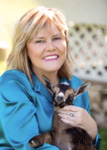 Katherine Myer holds a brown baby goat