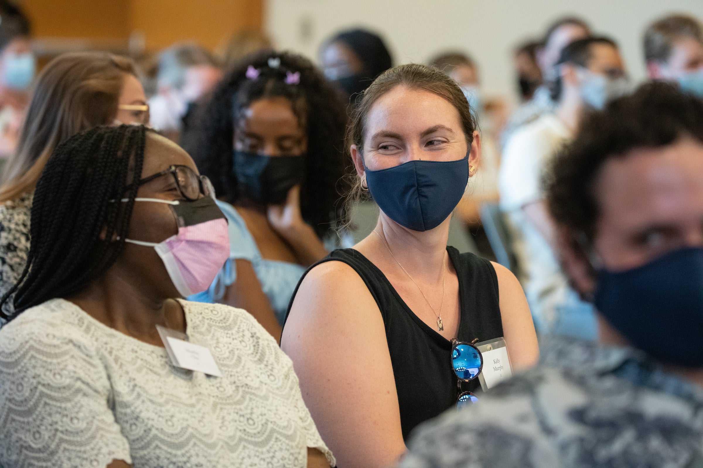 Two women smiling at eachother through masks