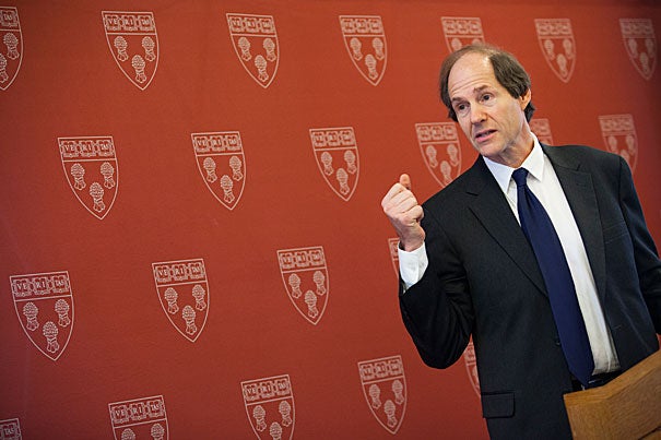 Cass Sunstein speaking in front of an HLS backdrop