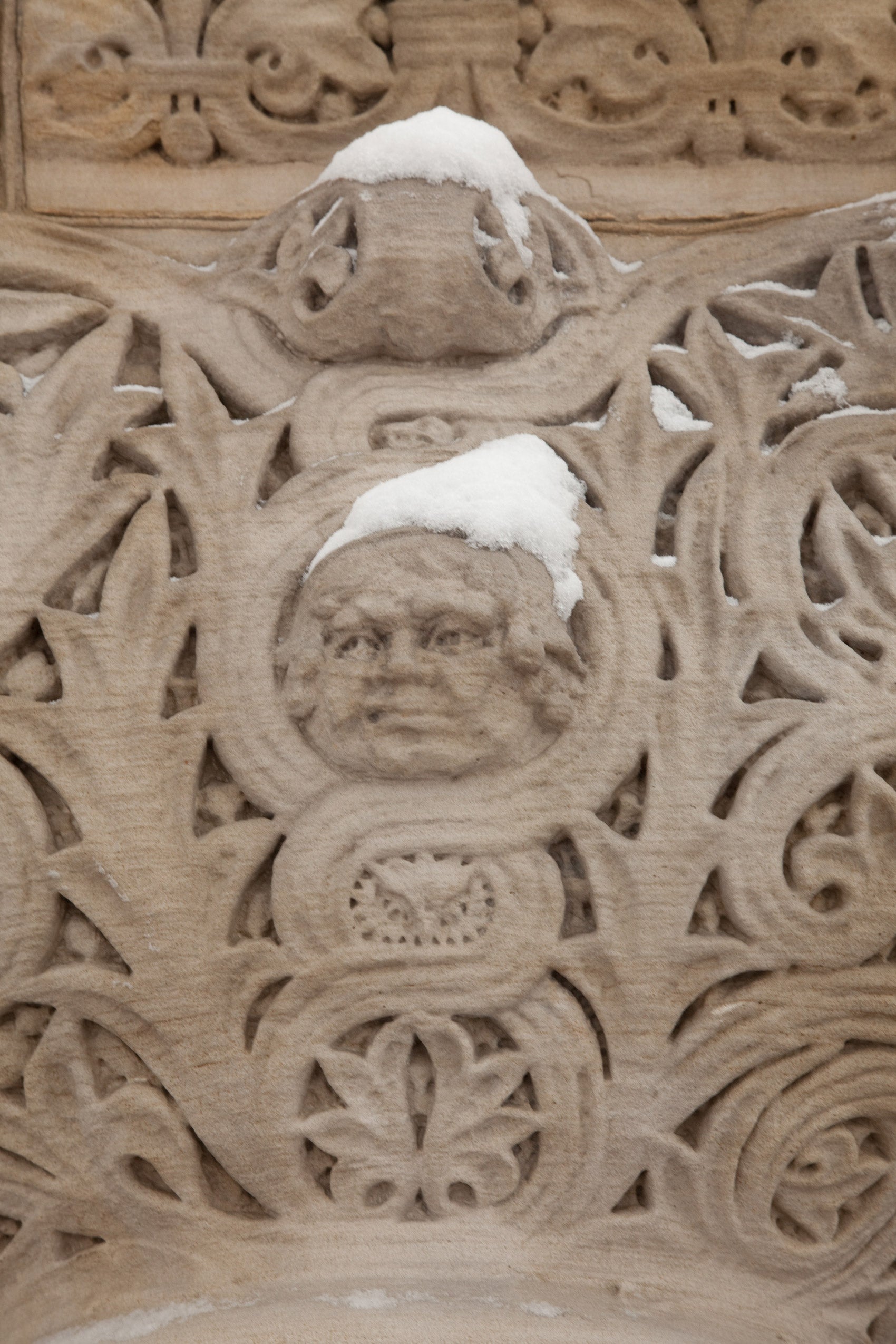 Snow on top of one of the heads carved into Austin Hall