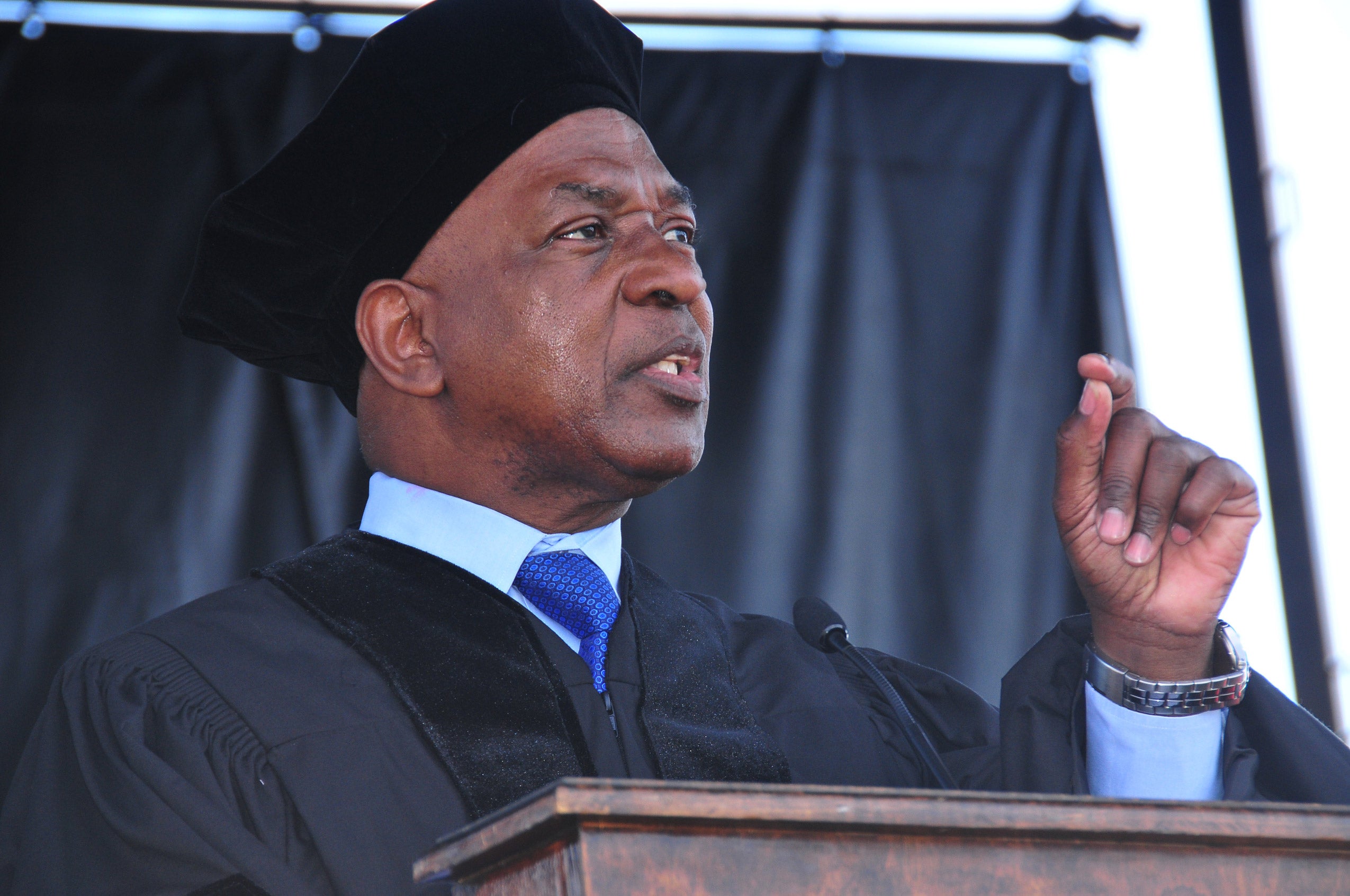 Professor Charles Ogletree speaking in commencement robes and hat