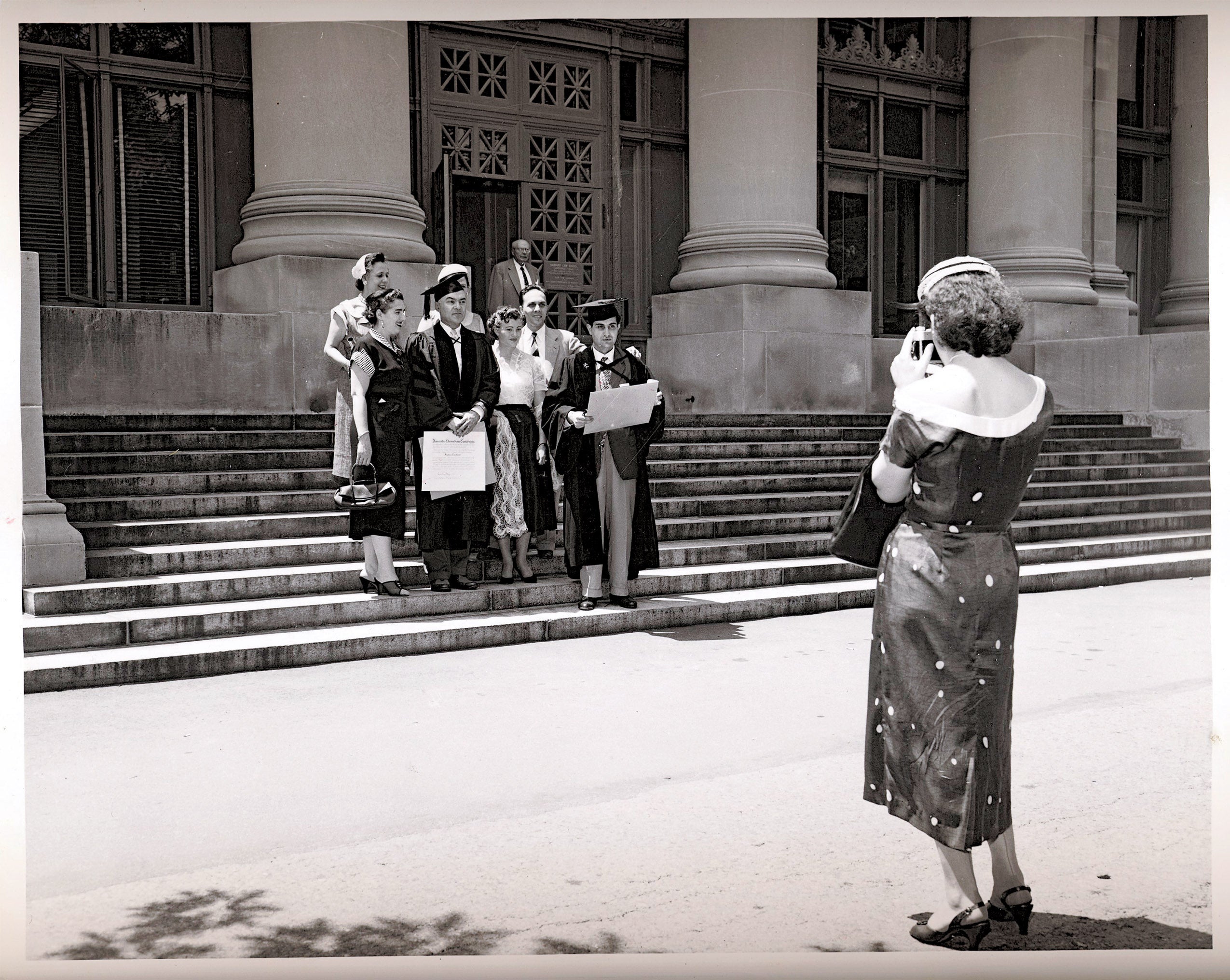 Woman takes a photo of 1955 graduates
