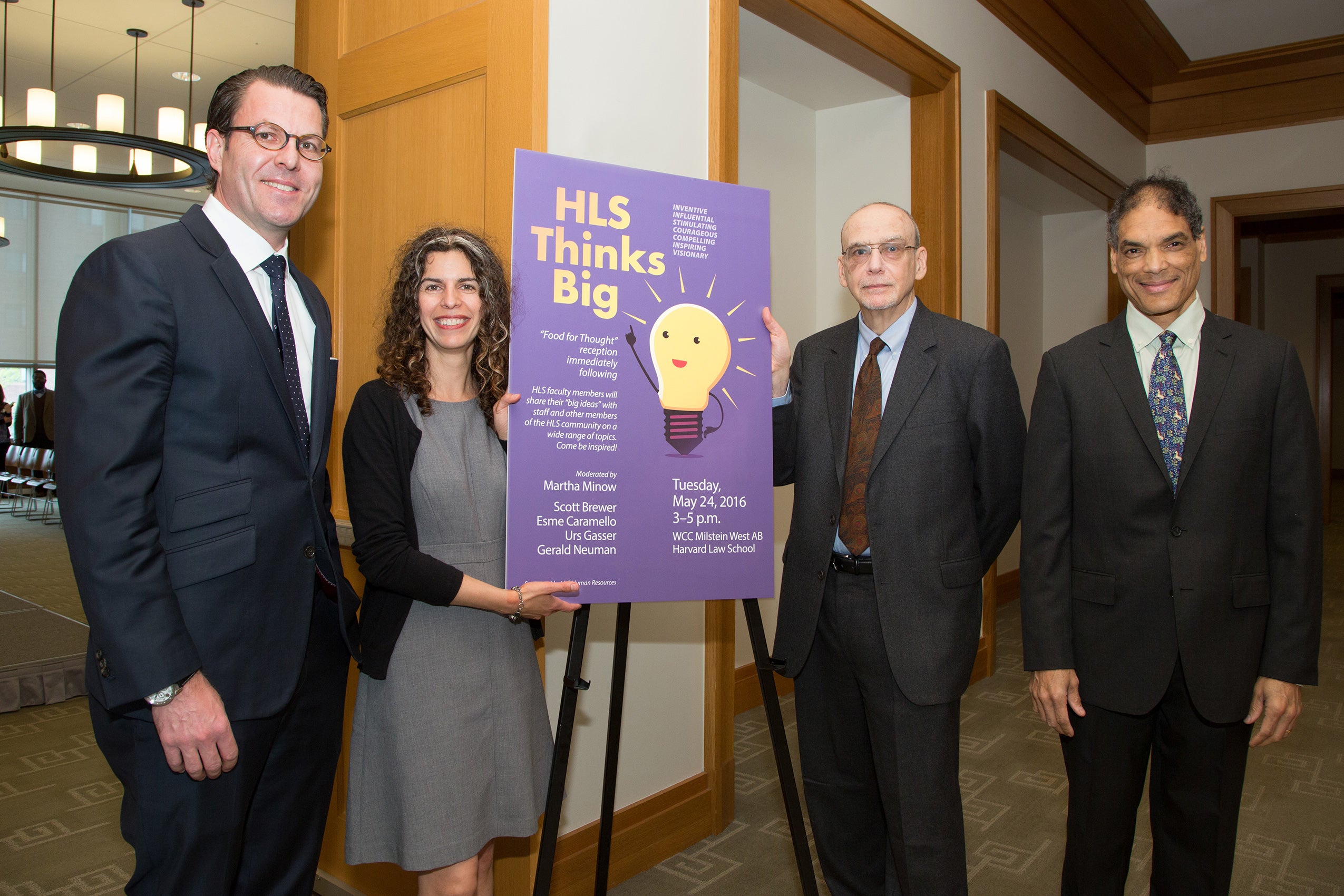 4 attendees standing beside an HLS Thinks Big sign