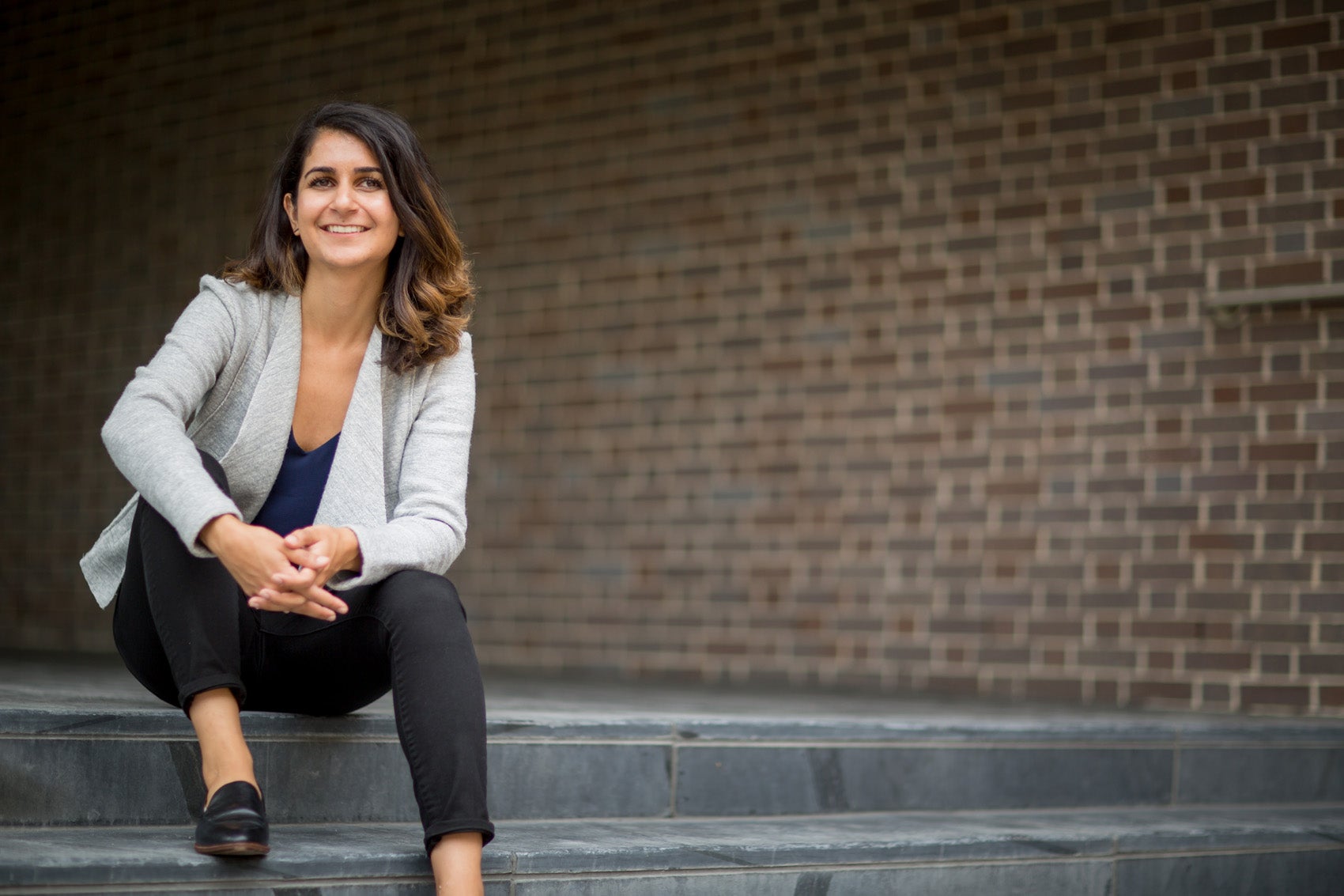 Niku Jafarnia sitting outside on the steps of Pound Hall as Harvard Law