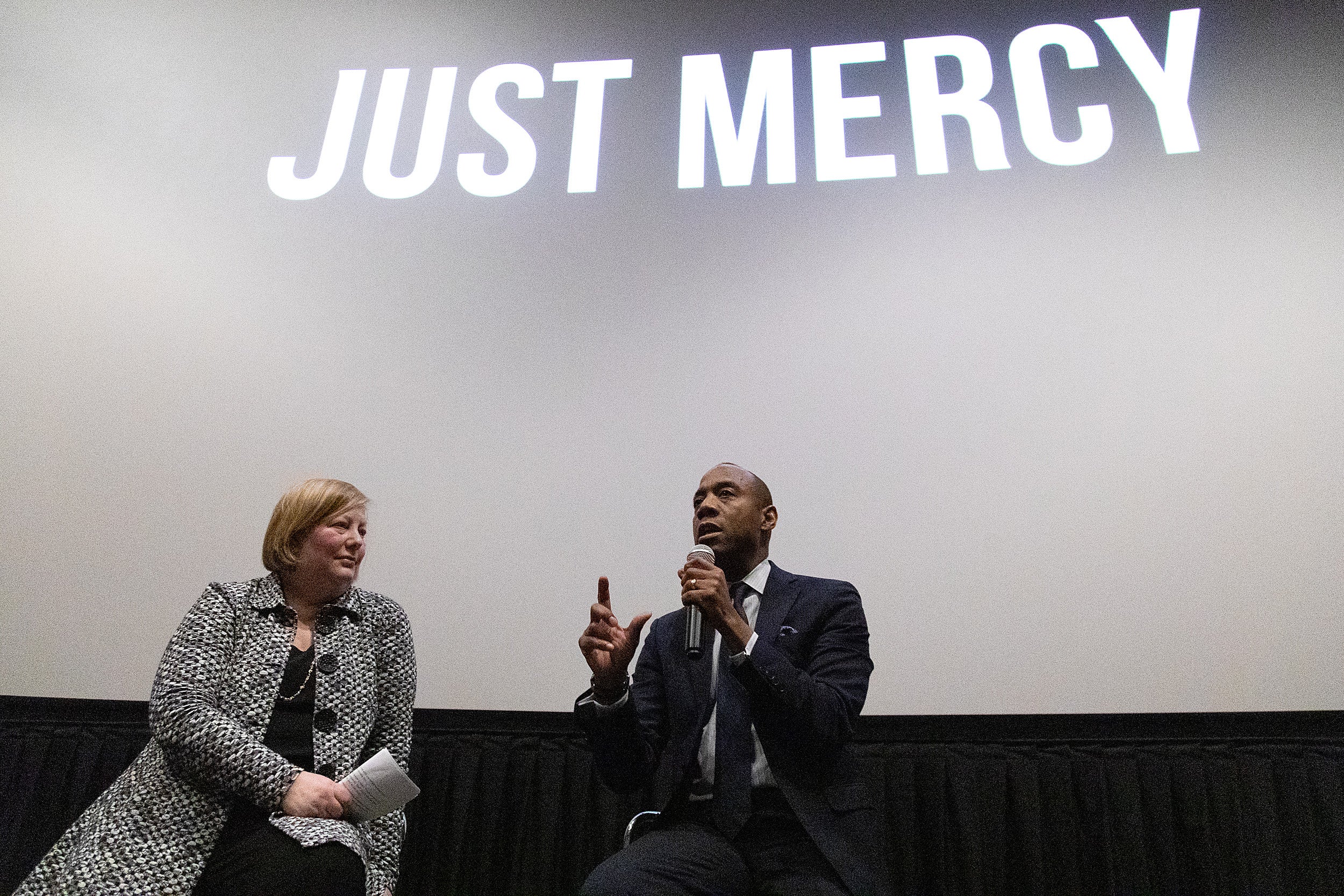Carol Steiker and Cornell William Brooks sit in front of movie theater screen reading Just Mercy