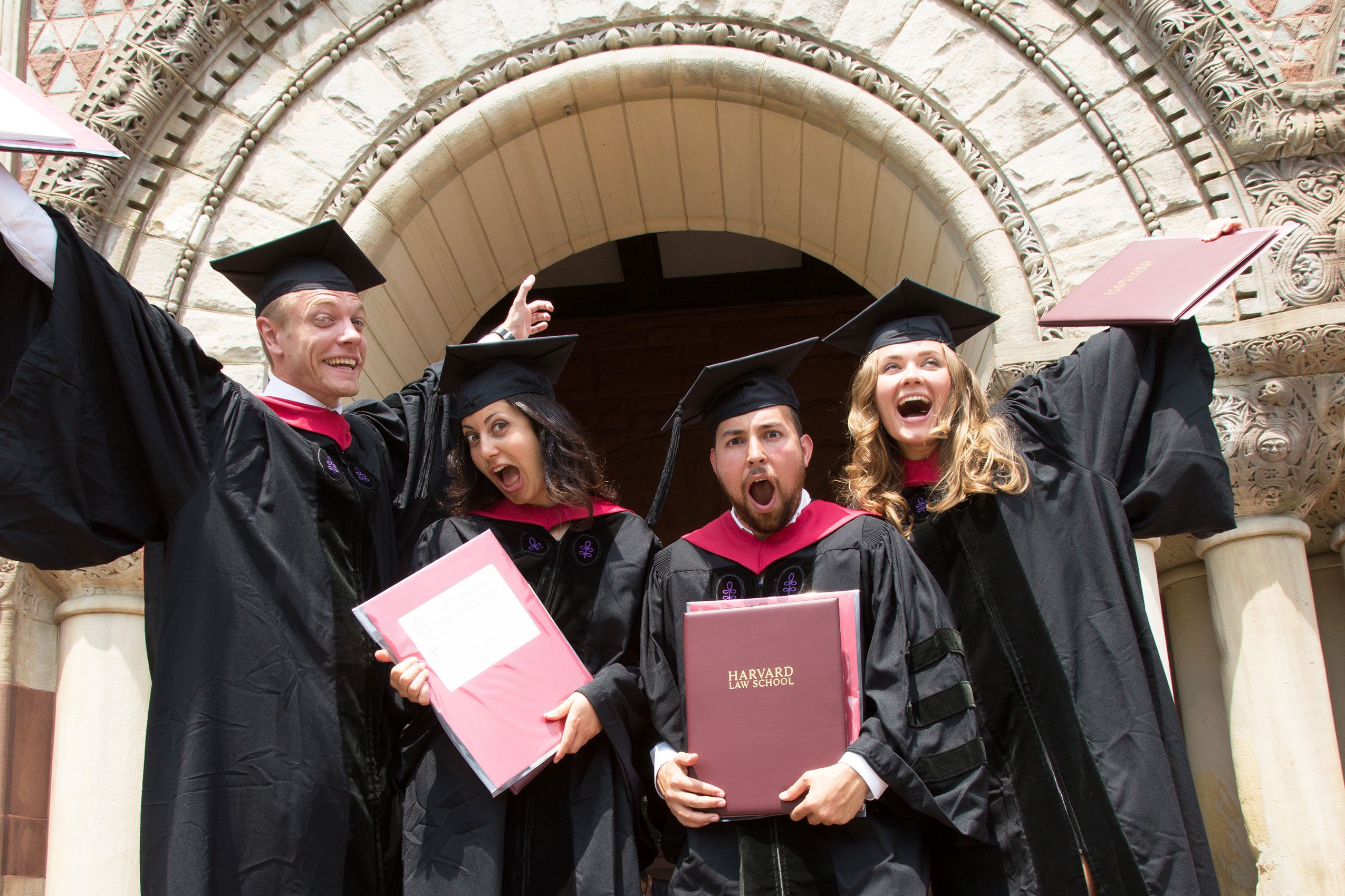 Graduates celebrating inside a marble arch