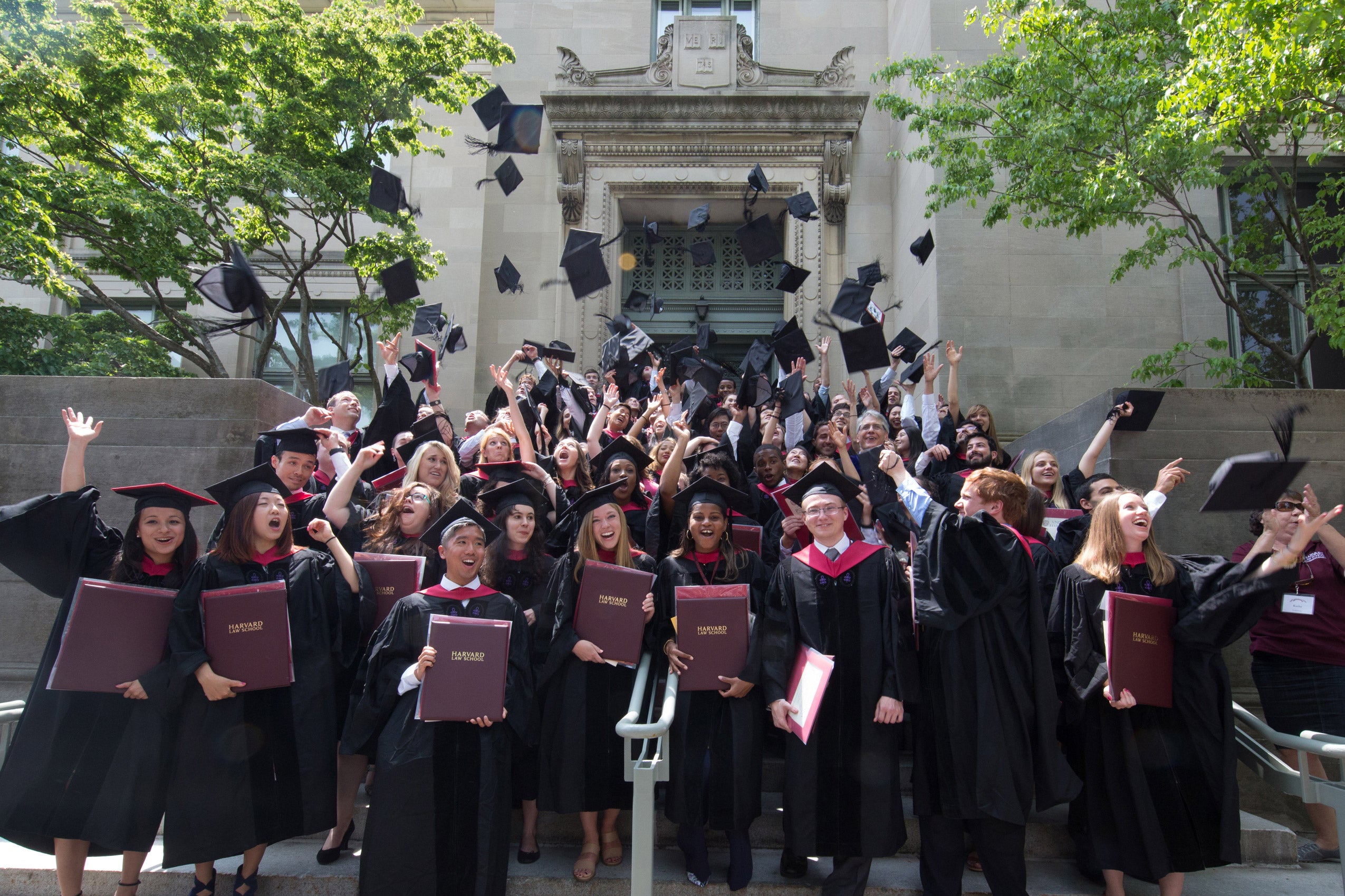 Graduates tossing their grad caps into the air