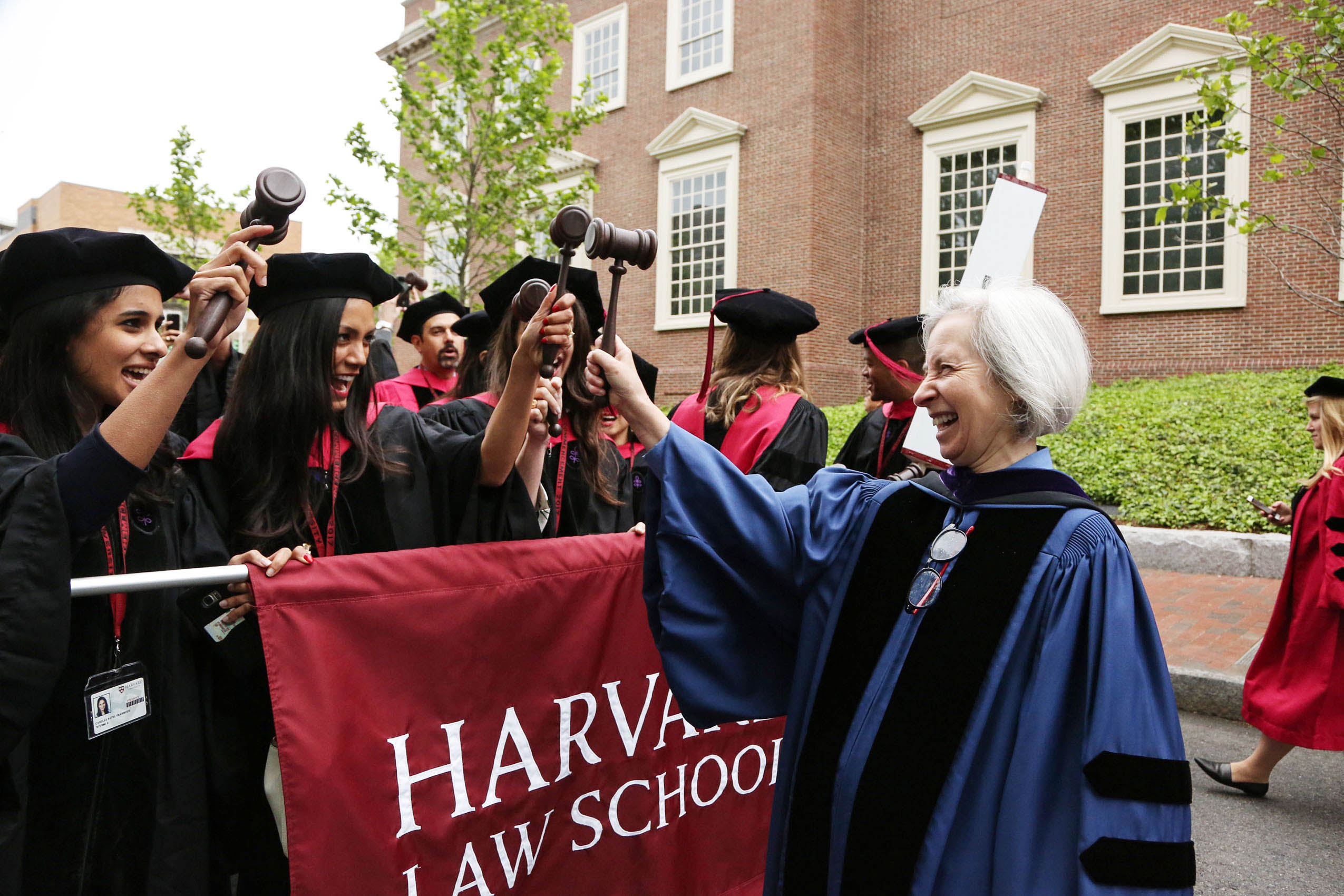 Martha Minow holding up gavel with students in robes