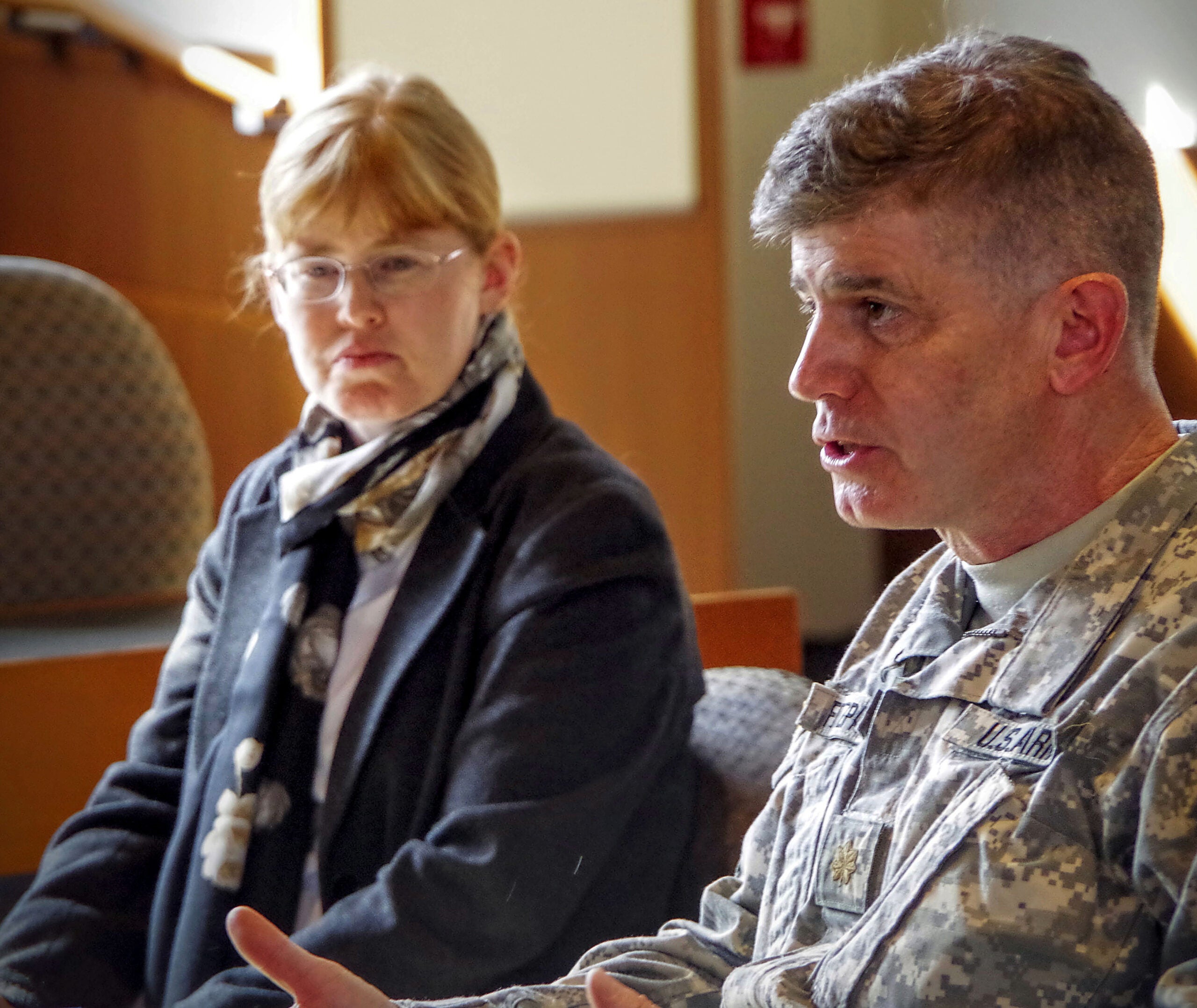 John Fitzpatrick in Army uniform speaking with an attendee watching in the background