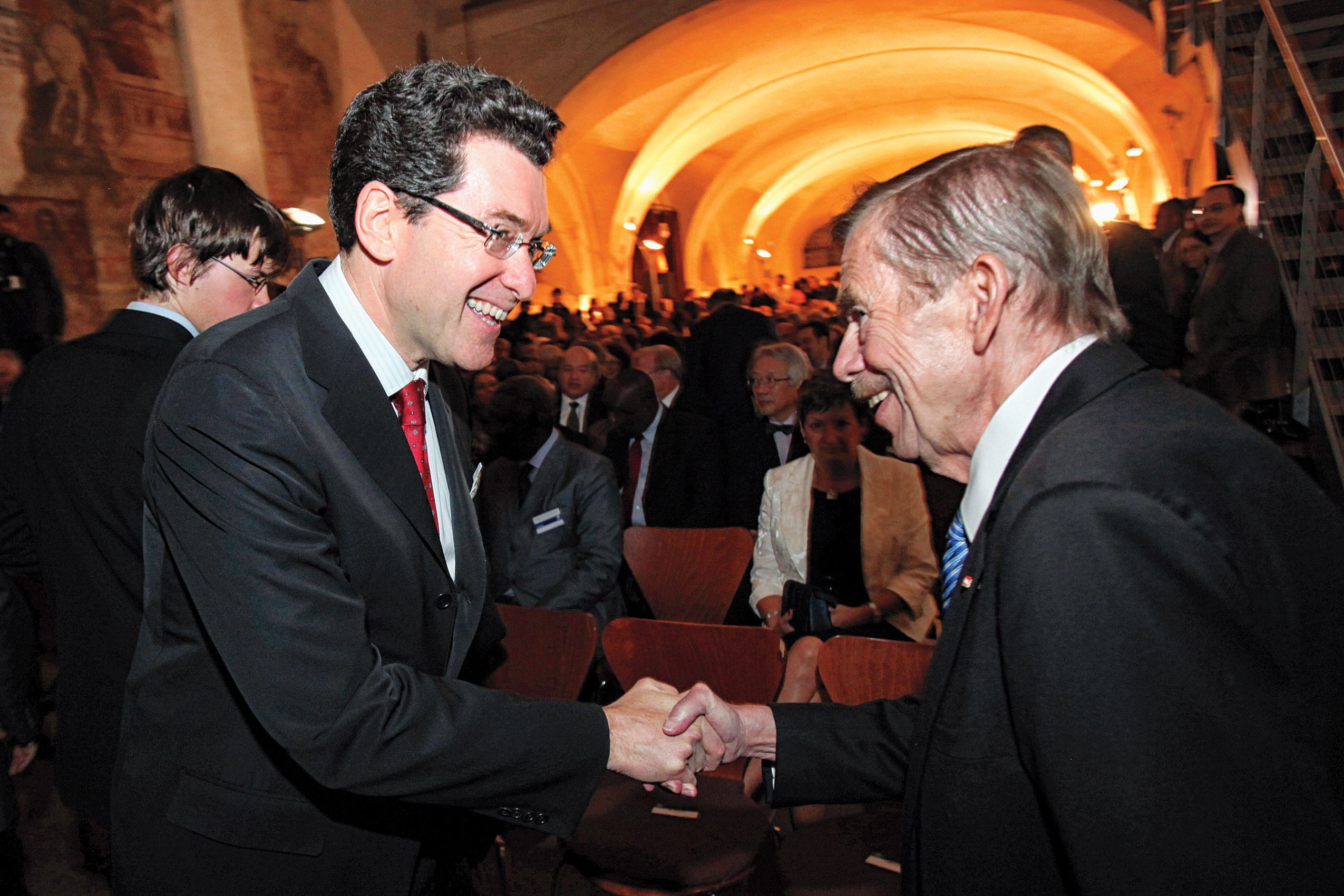 Norman Eisen shaking hands with Vaclav Havel at an indoor event