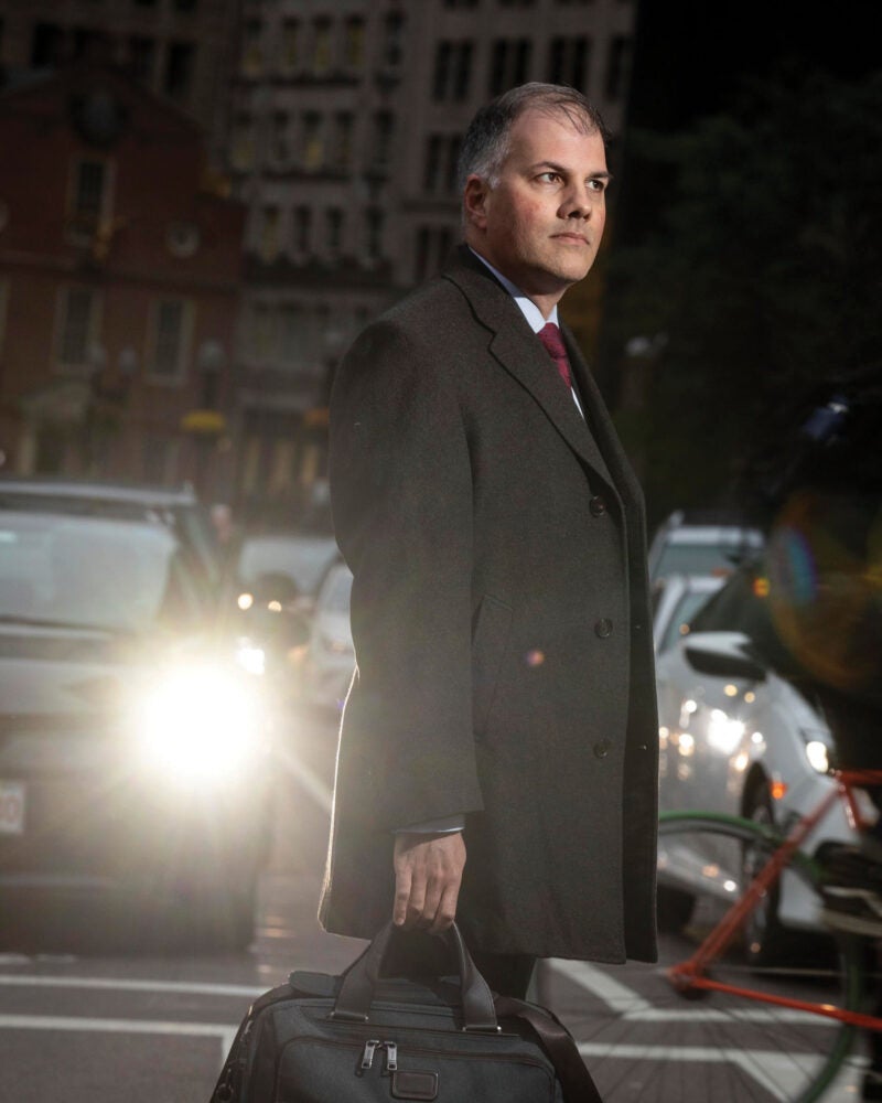 Mark Fleming '97 standing in a crosswalk with cars behind him