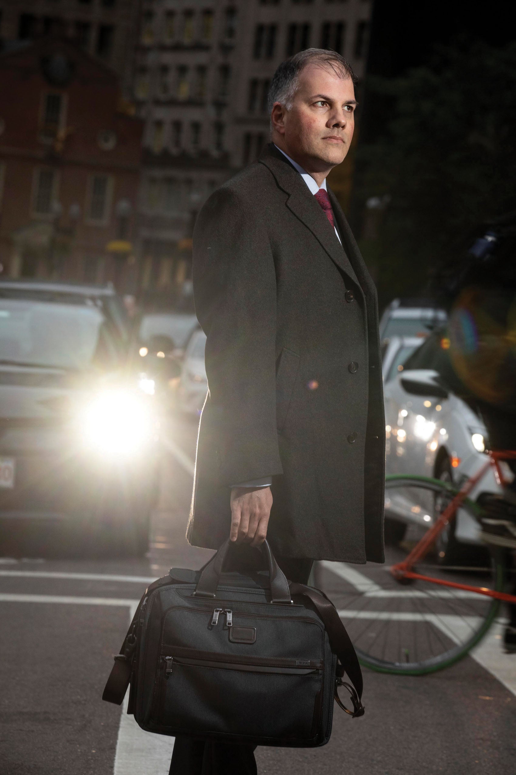 Mark Fleming '97 standing in a crosswalk with cars behind him