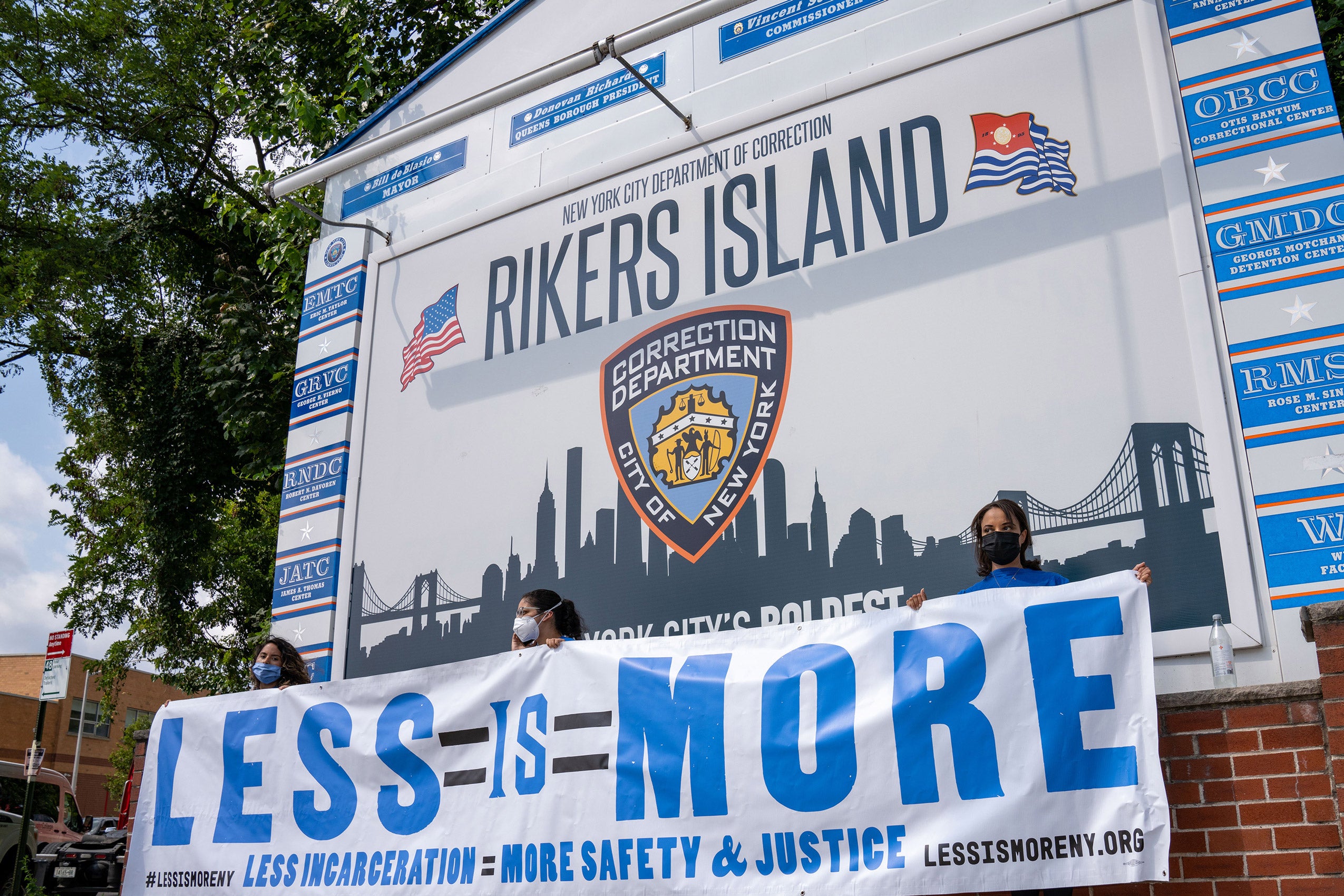 Large sign that says Rikers Island with a sign below it that says 