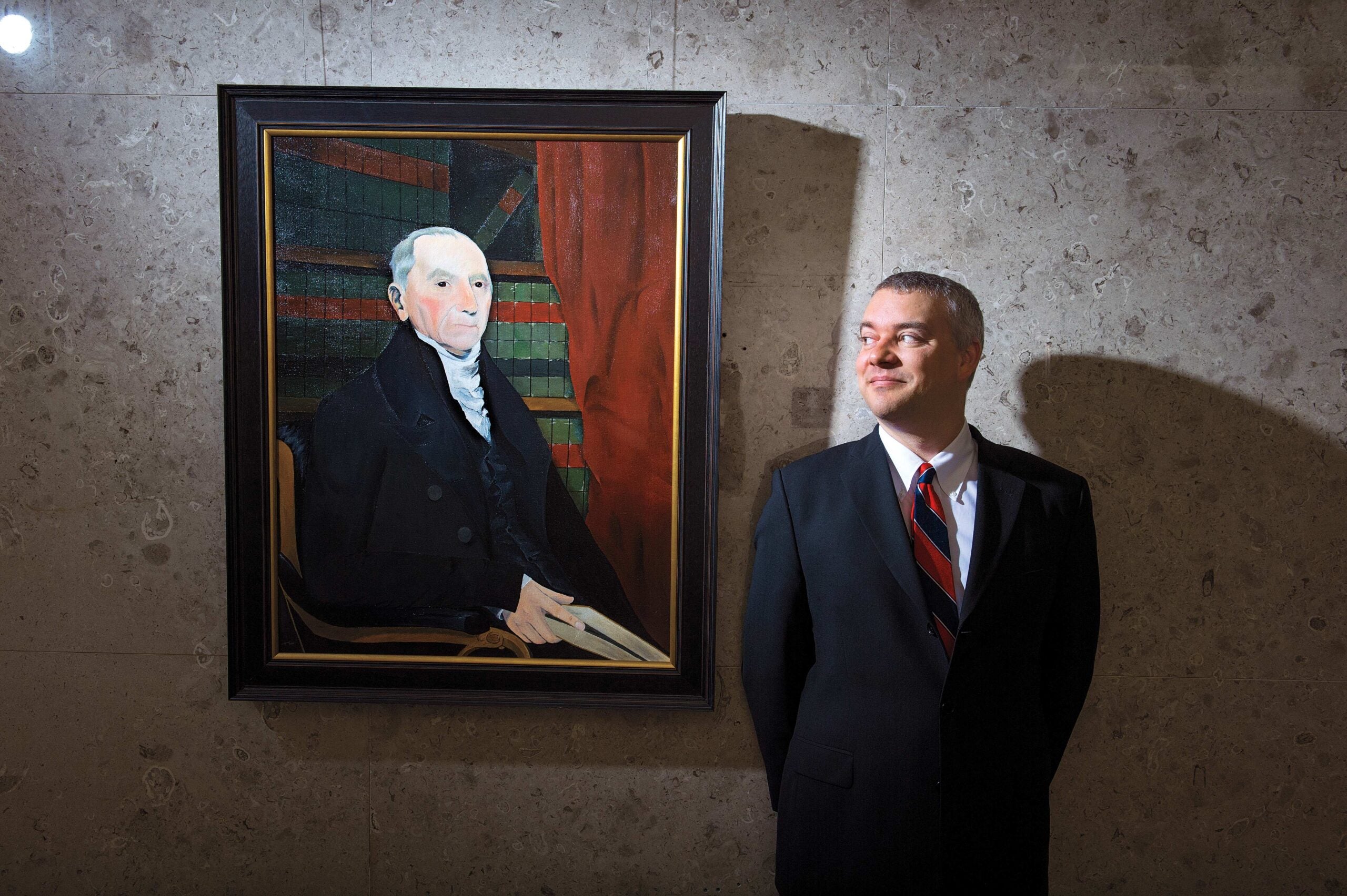Tim Kiefer ’98 standing next to portrait of Nathan Dane