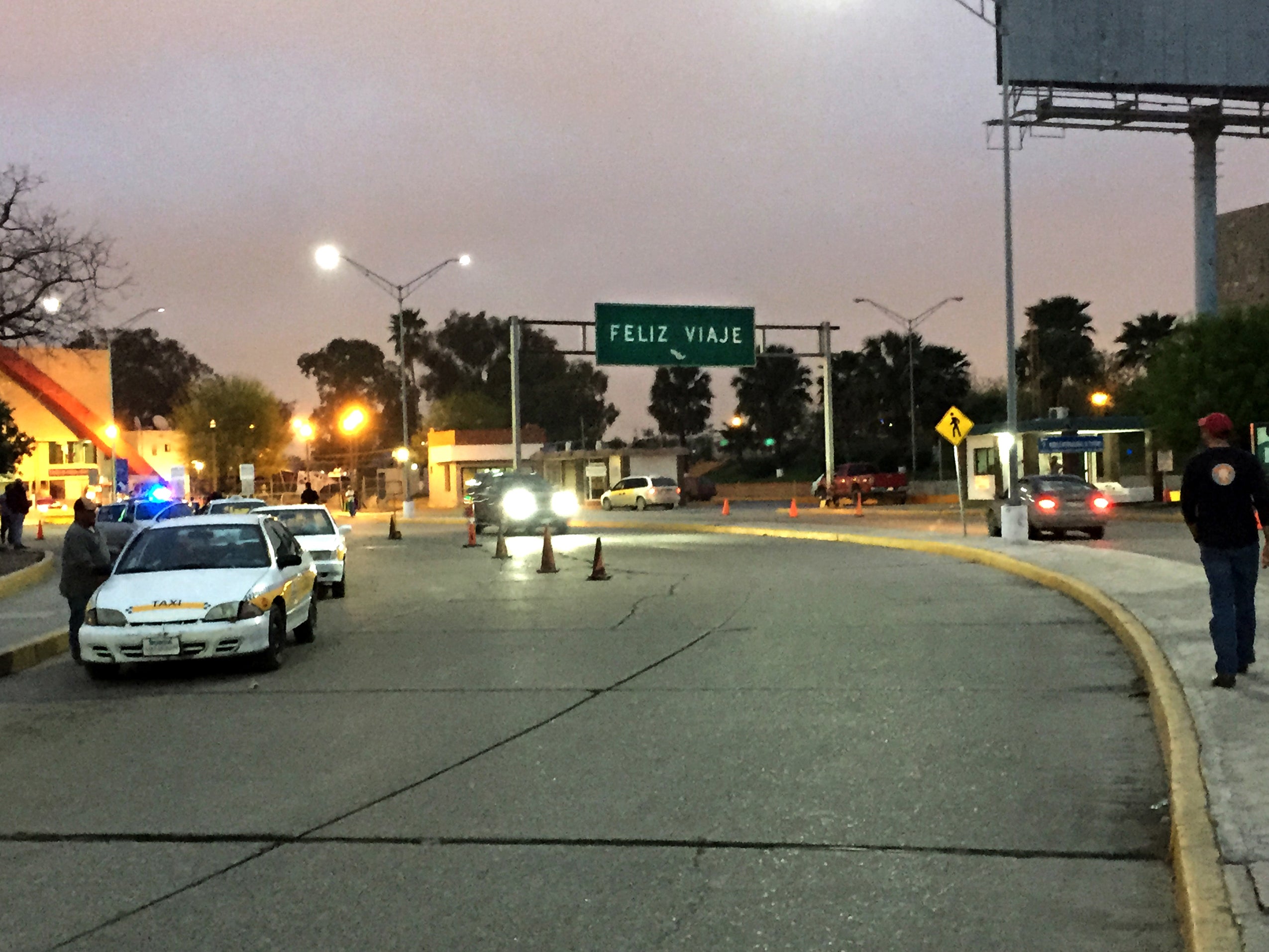 View from the street showing police pulled over and a street sign that says Feliz Viaje