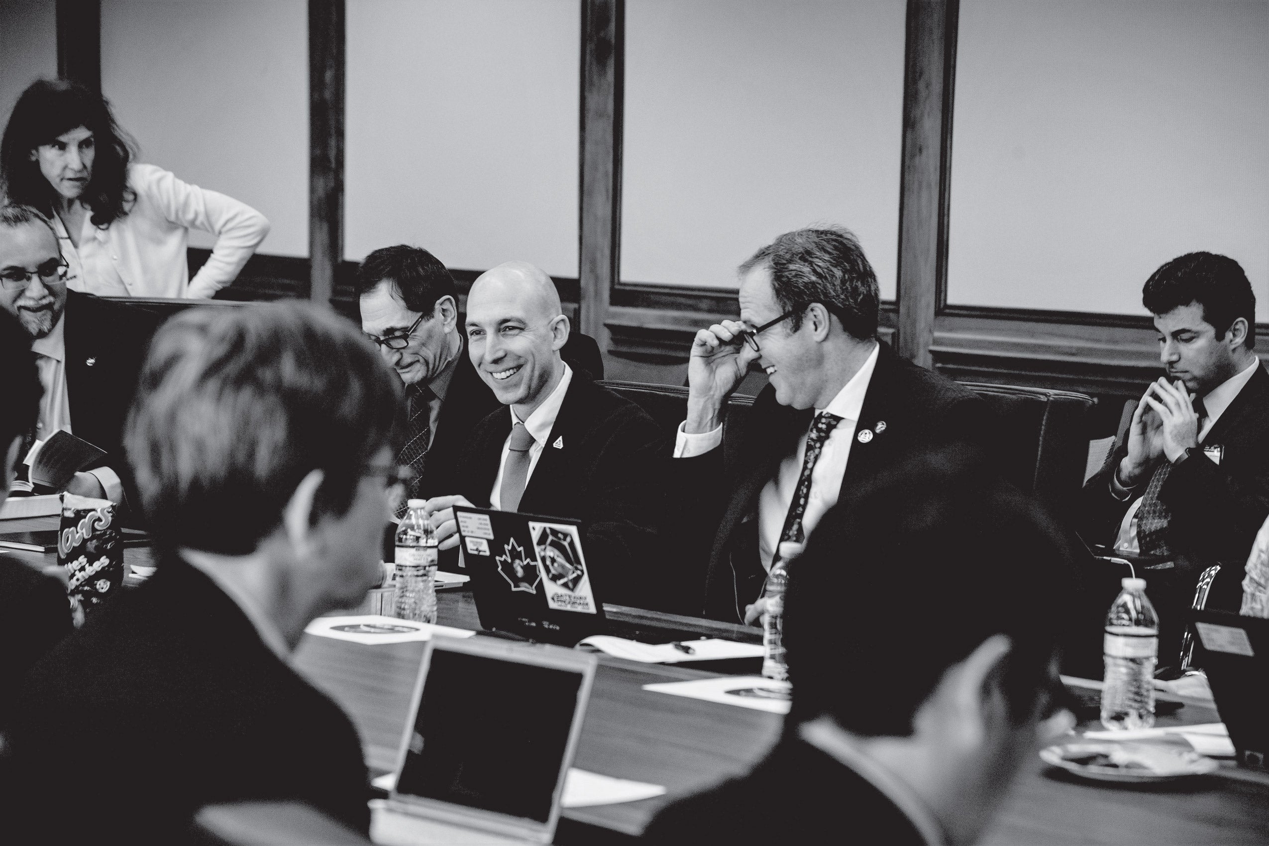 Black and white photo of a group of people at a conference table