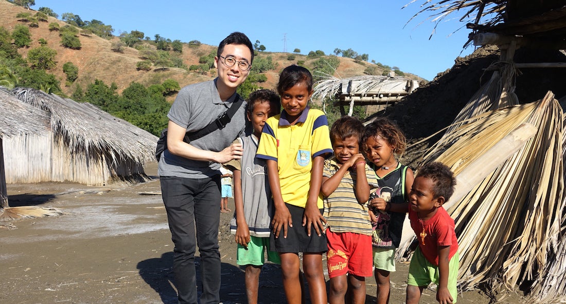 Ha Ryong Jung posing with 5 children near their hut