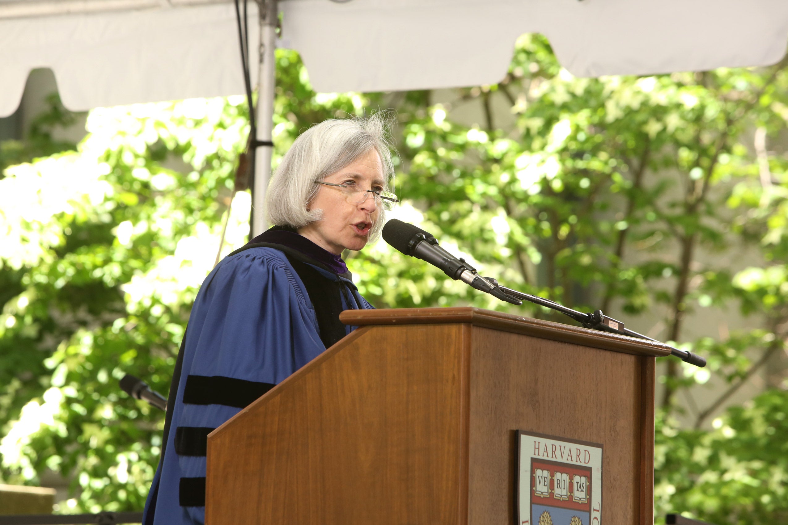 Martha Minow in ceremony robes speaking at podium