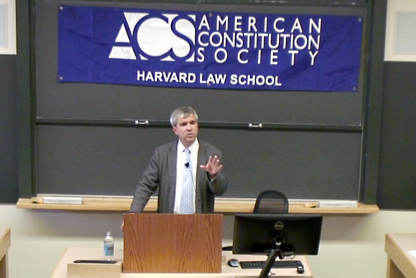 Santiago Legarre speaking at the front of the room with an American Constitution Society banner behind him