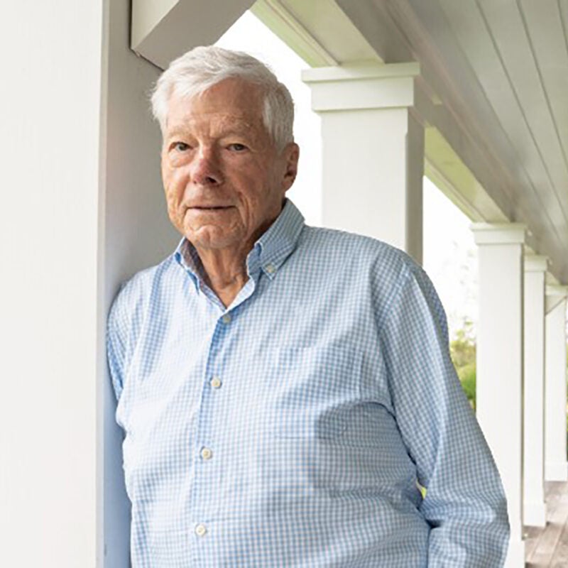Man outside of a house leaning against a pillar