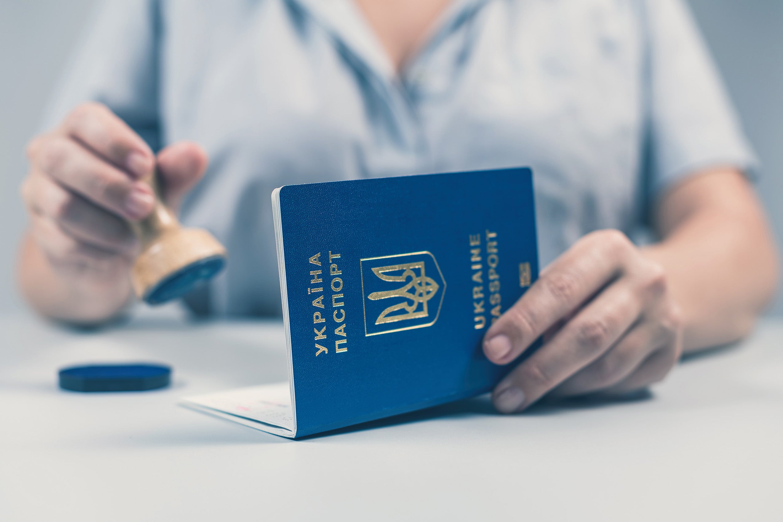 Border control officer puts a stamp in a Ukrainian passport