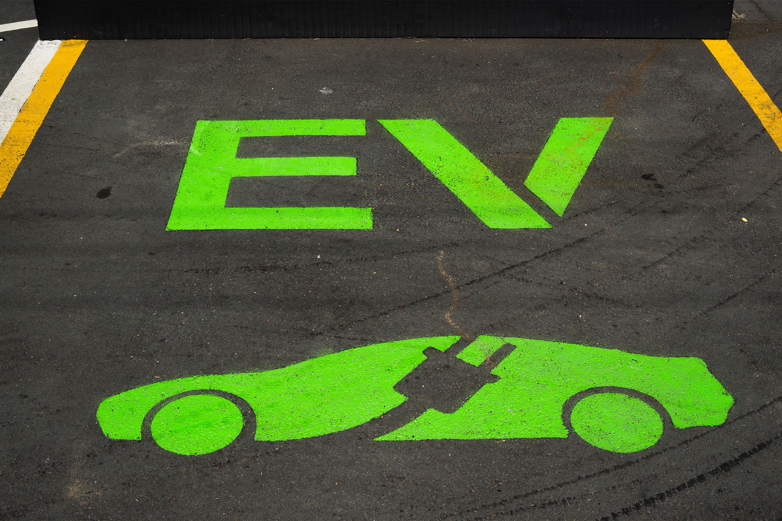 Electric vehicle parking space marked with a green stencil of the letters 