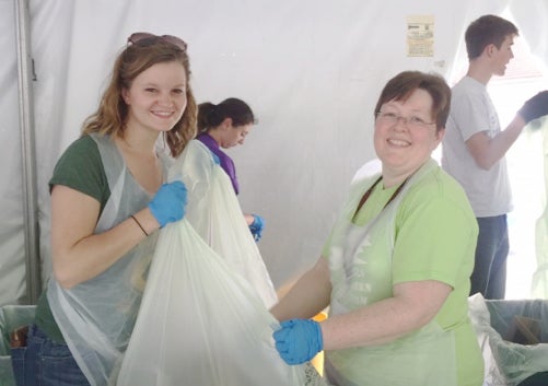 Carrie Ayers and Jacquelyn Kenehan, smiling while sorting trash