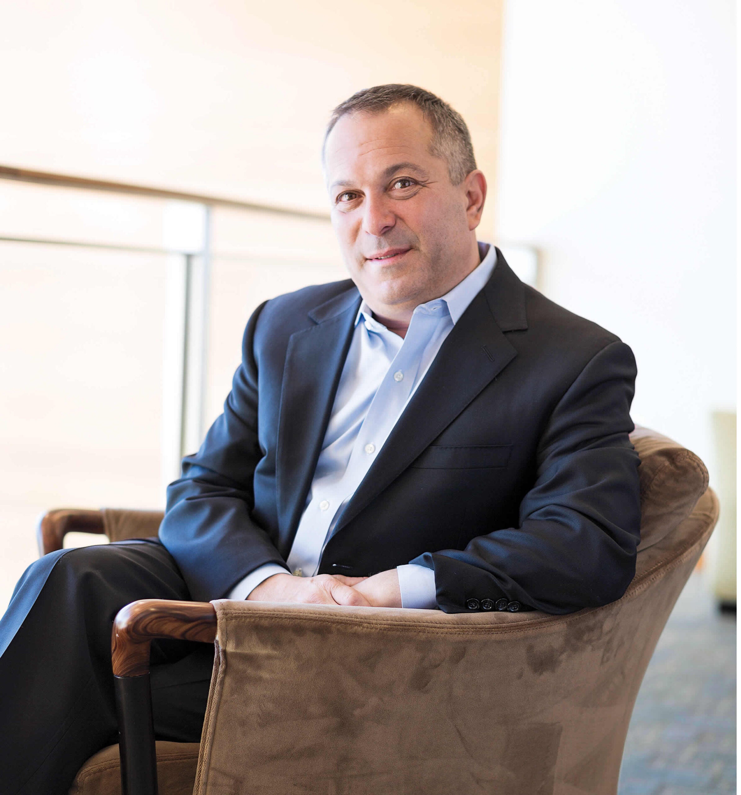 Portrait of Robert Greenwald seated in an armchair