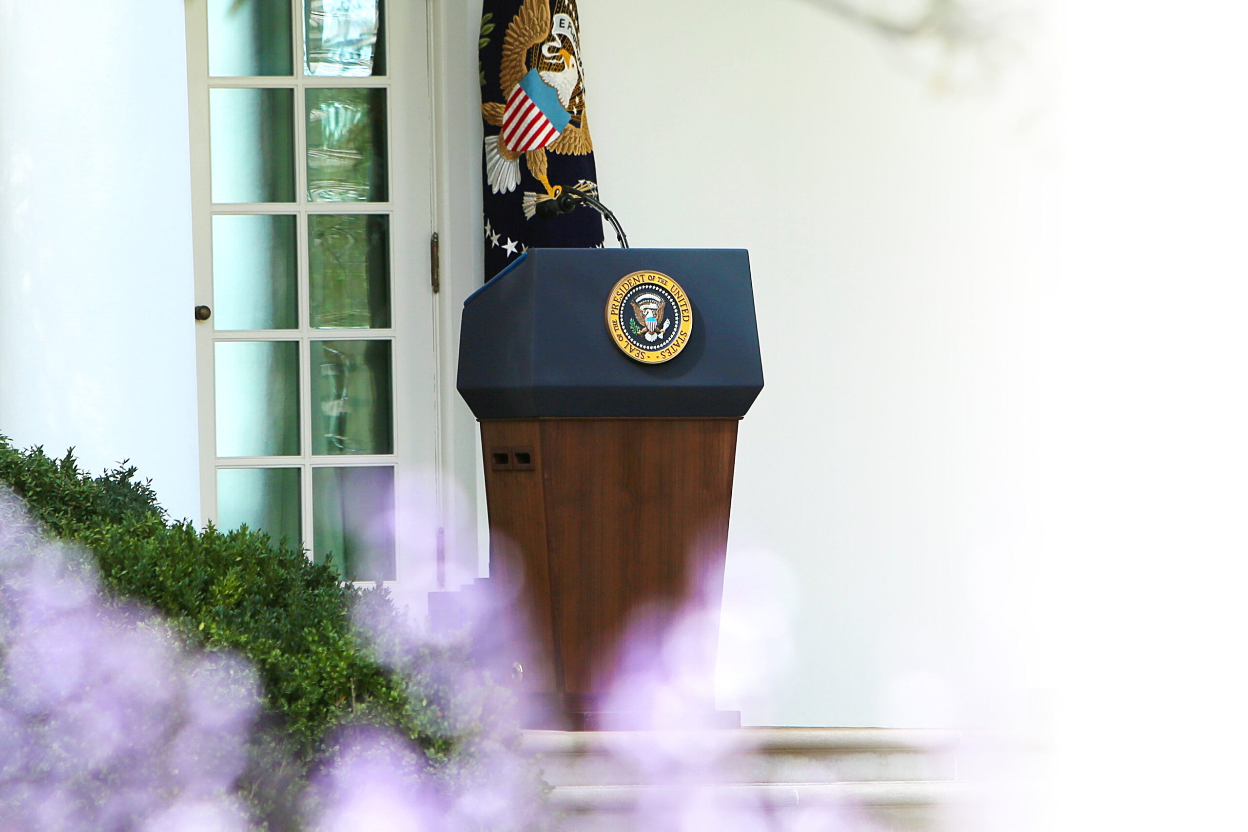 President of the United States Podium outside next to a paneled glass door.