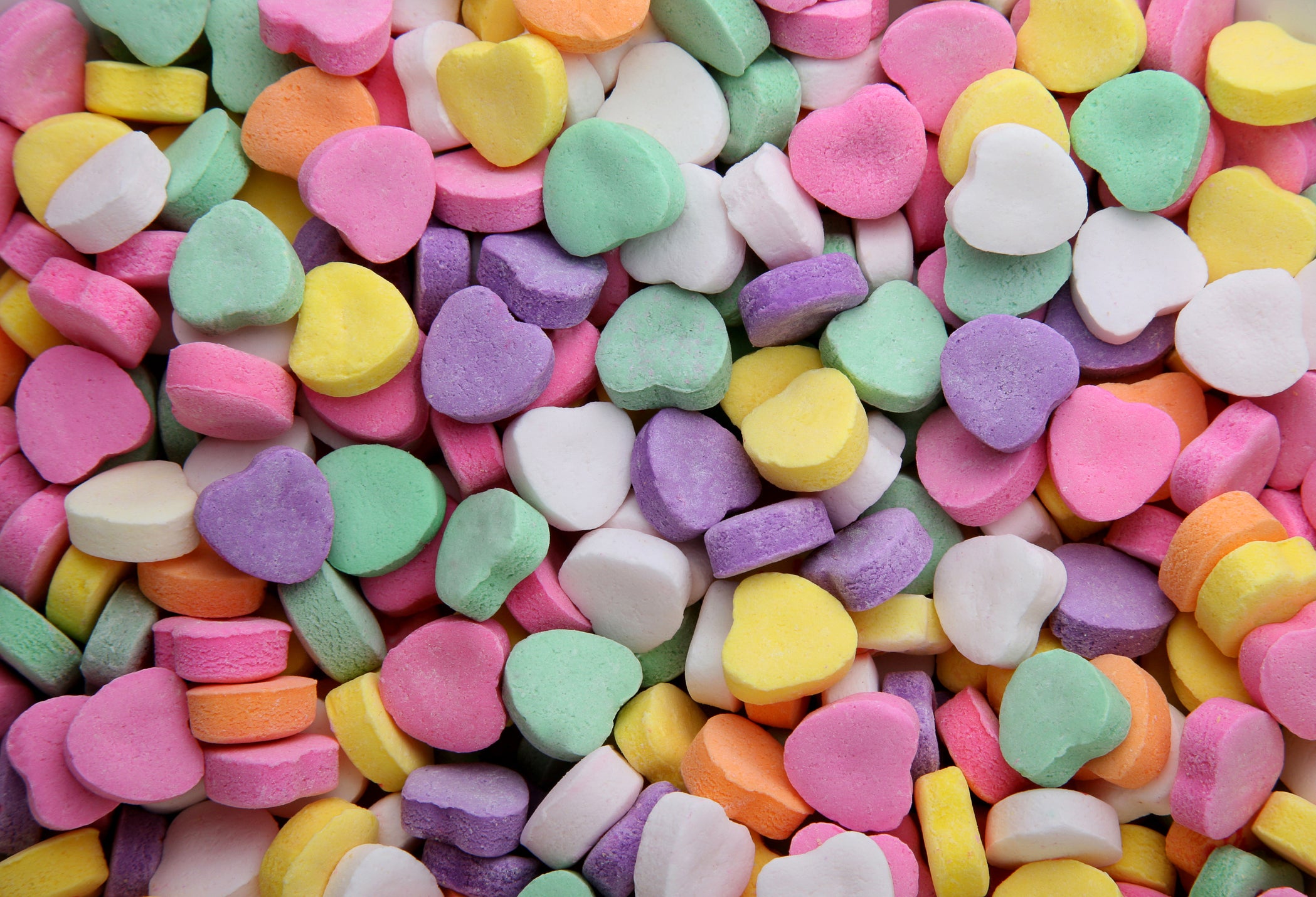 Close up of multi-colored small candy hearts.