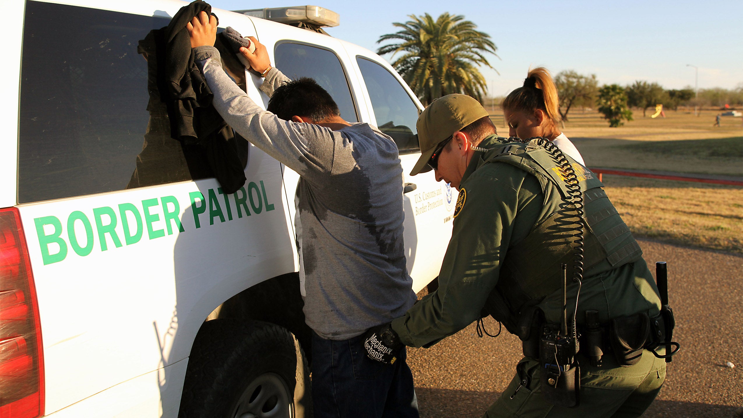 Border patrol agent taking man into custody