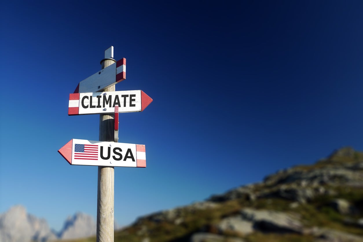 Sign that points to the climate and USA in opposite directions