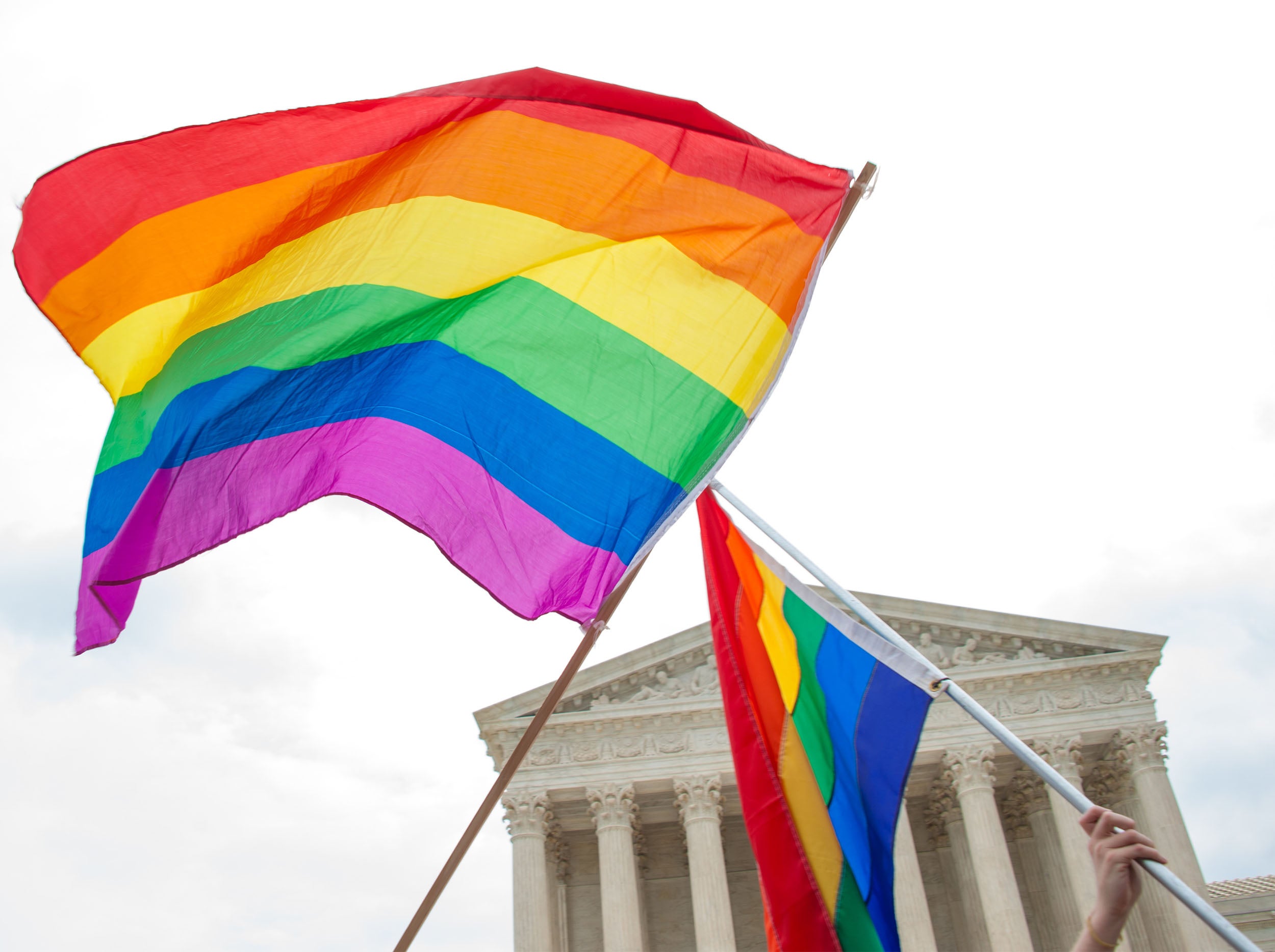 Two rainbow flags waving in front of the U.S. Supreme Court.