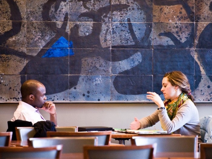Two People having a discussion at a table in the WCC