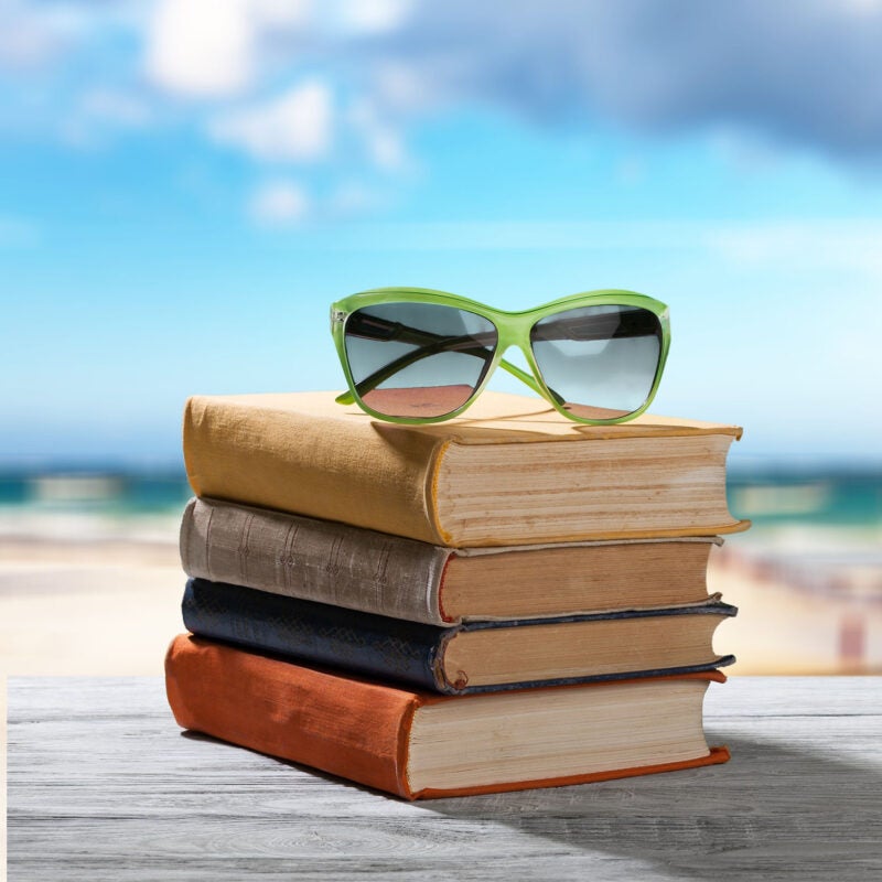 Sunglasses on top of a stack of books at the beach
