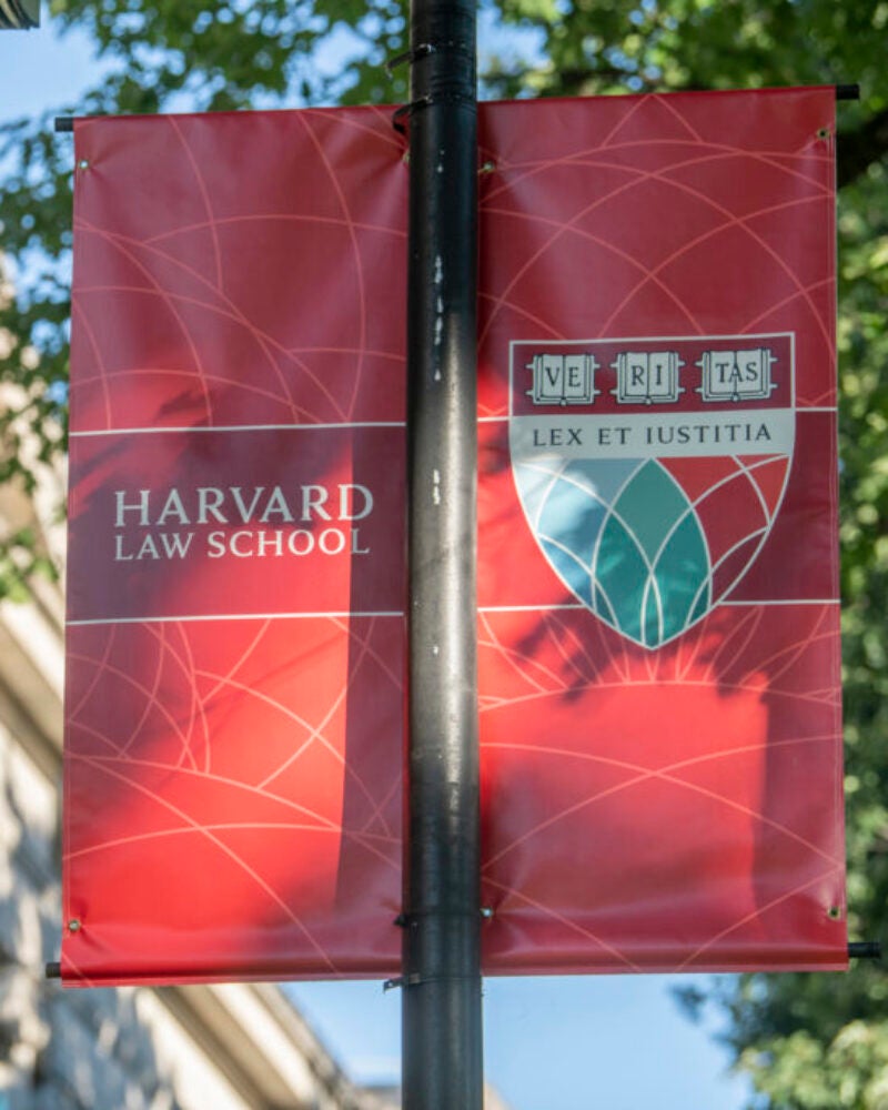 Harvard Law School banners with Landgell Hall in the background.