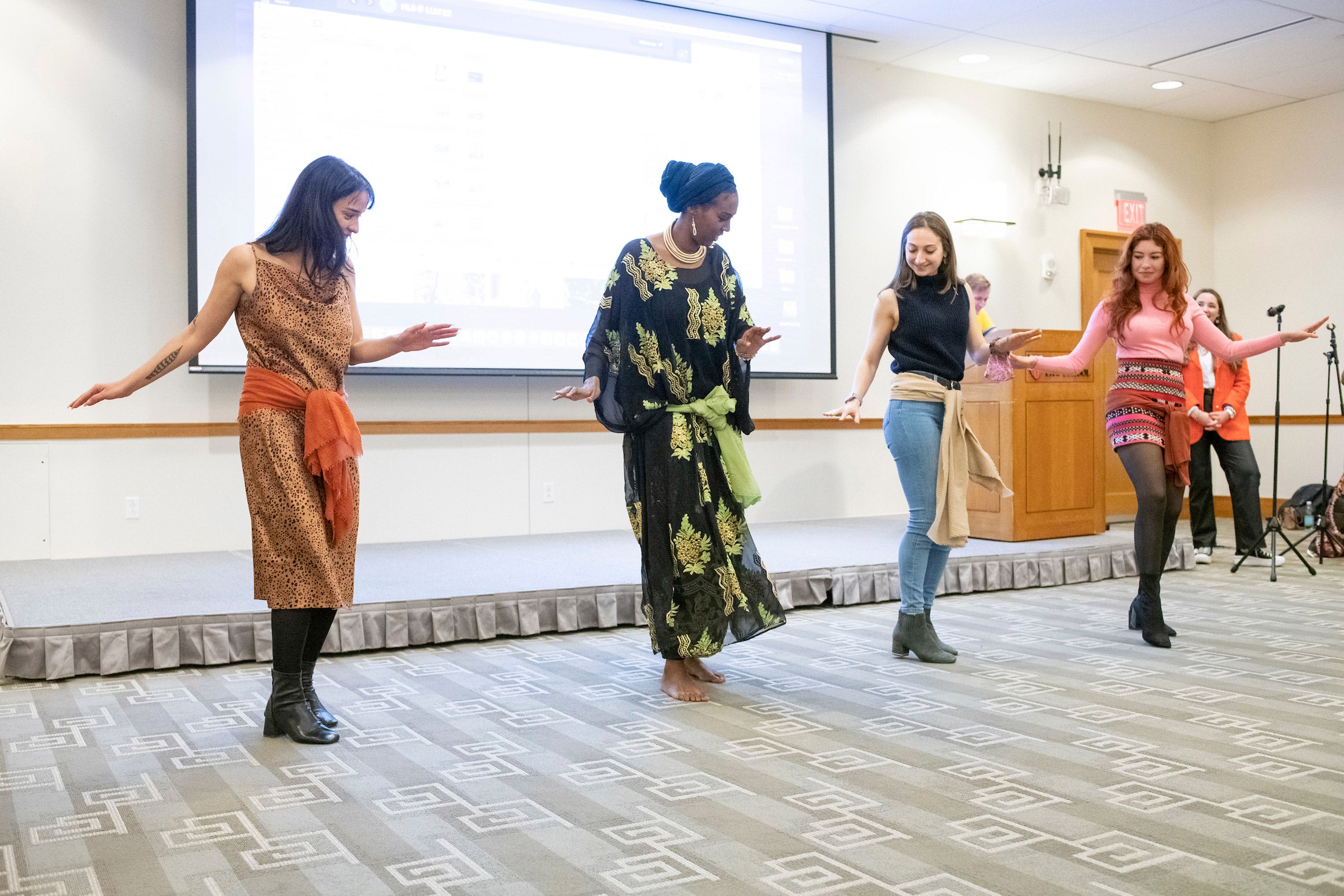 A line of 4 women learn a dance step