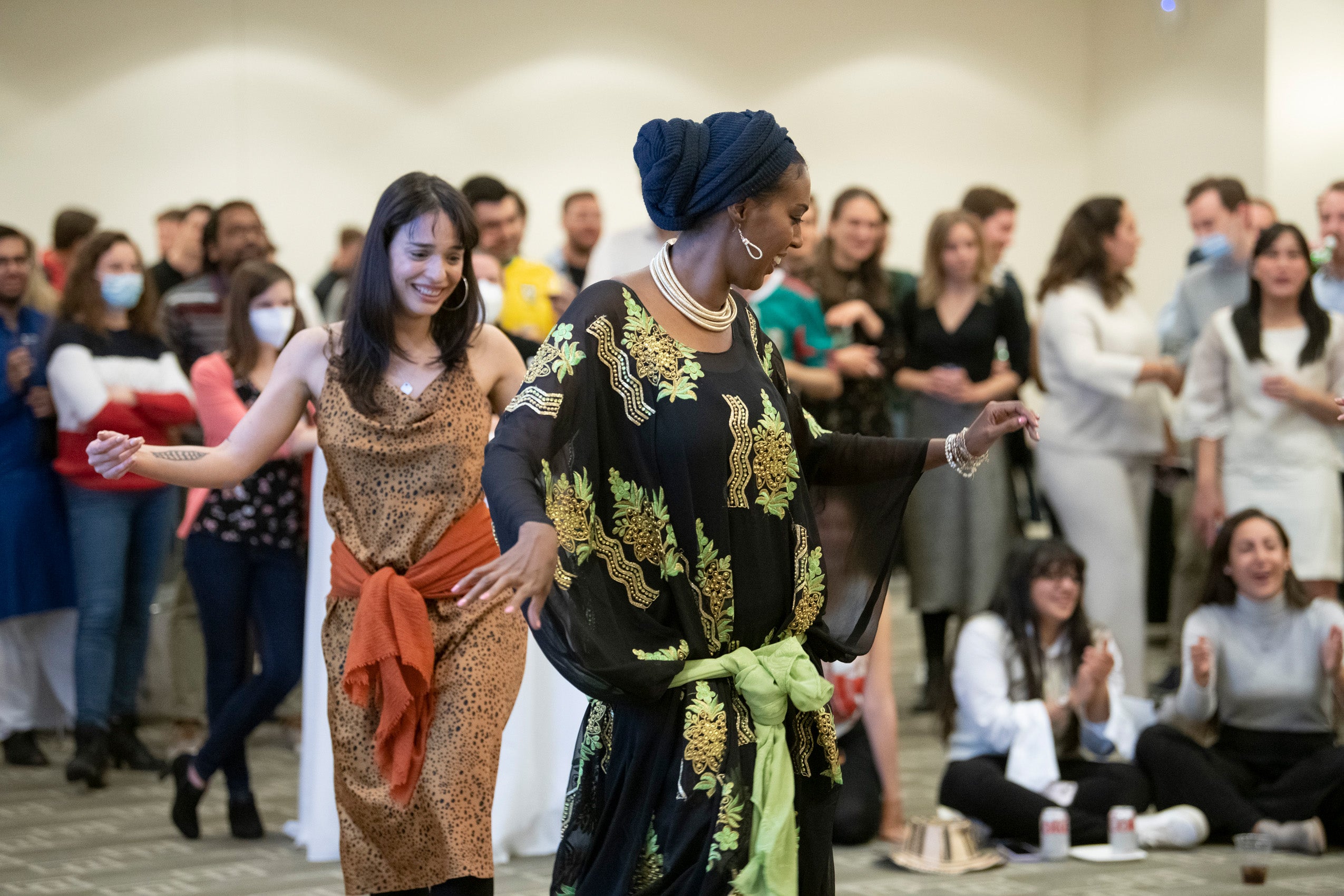 A graduate student teaches classmates a dance at an event